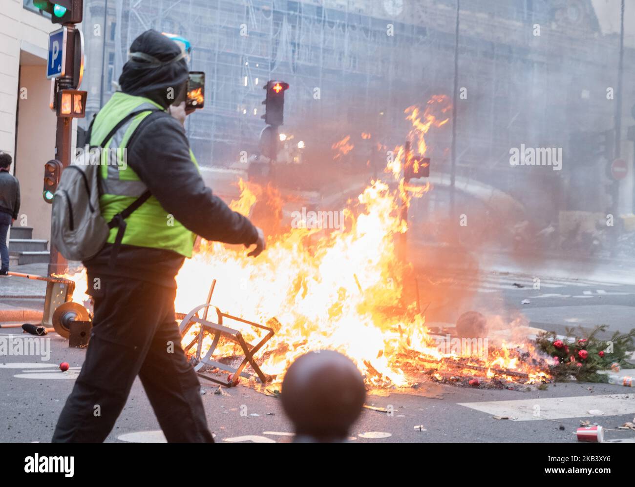 Protesta di fronte a una barricata in fiamme vicino agli Champs Elysees il 8 dicembre 2018 a Parigi, Francia. Le proteste del gilet ('Gilet Jaunes') hanno distrutto Parigi e altre città francesi per quasi un mese, poiché il movimento - ispirato dall'opposizione ad una nuova tassa sui carburanti - ha assorbito un'ampia gamma di sentimenti anti-governativi. (Foto di Estelle Ruiz/NurPhoto) Foto Stock