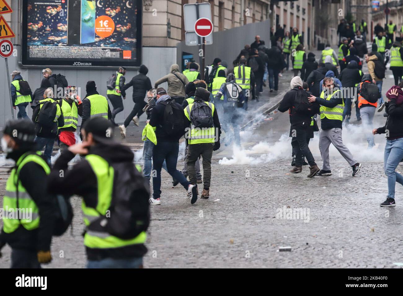 Manifestanti visti nel fumo di gas lacrimogeno a Champ Elysees vicino all'Arco di Trionfo durante la dimostrazione del gilet giallo. Scontri e vandalismo che hanno provocato migliaia di arresti, di cui più di 1.700 sabato 8 dicembre 2018, scaturiscono dalle proteste dei “giubbotti gialli”, un movimento anti-governativo. Blocchi stradali e molte azioni tra i dimostranti e la polizia si sono verificati intorno all'Arco di Trionfo e agli Champs Elysees con negozi rotti, auto bruciate o danneggiate, blocchi stradali con fuoco, violenza e molto fumo di gas lacrimogeno dalla polizia. (Foto di Nicolas Economou/NurPhoto) Foto Stock