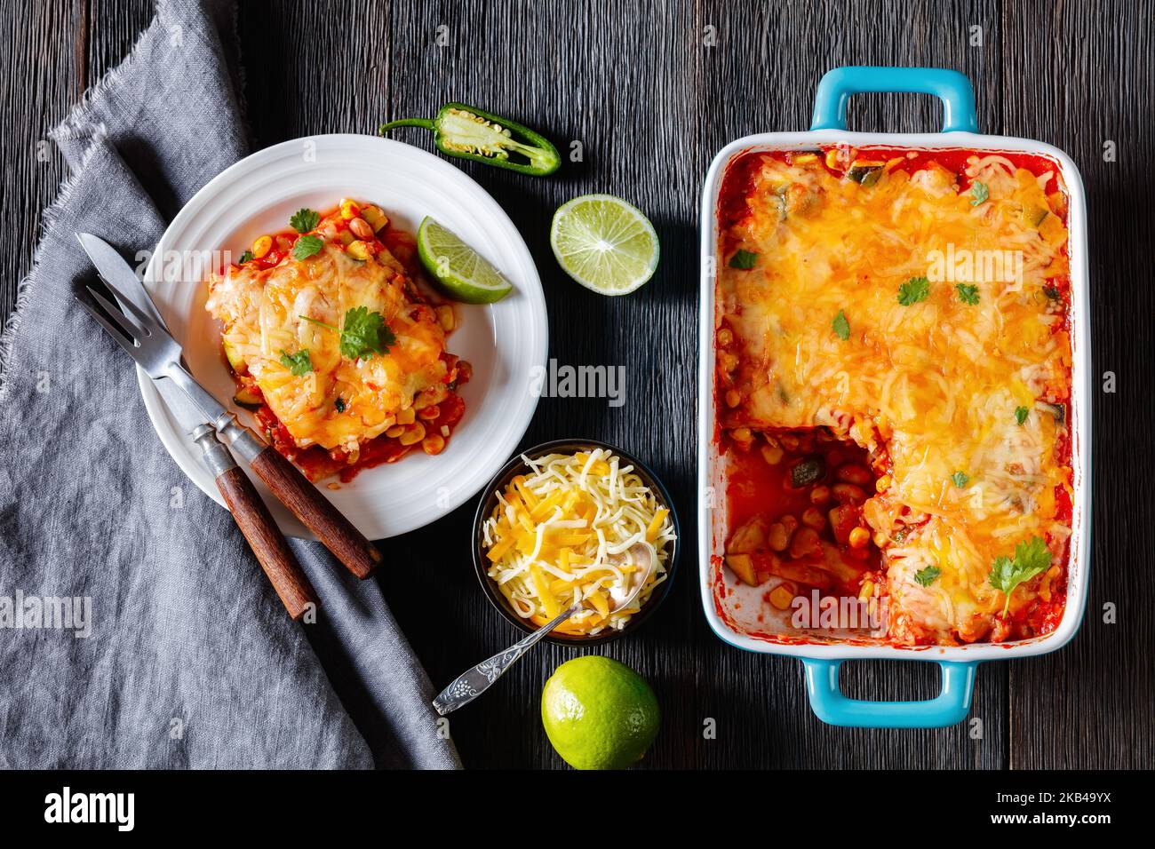 casseruola vegetariana di enchilada con tortilla, salsa, fagioli pinto, mais, zucchine e formaggio messicano mescolato in piatto da forno e su piatto, piatto Foto Stock