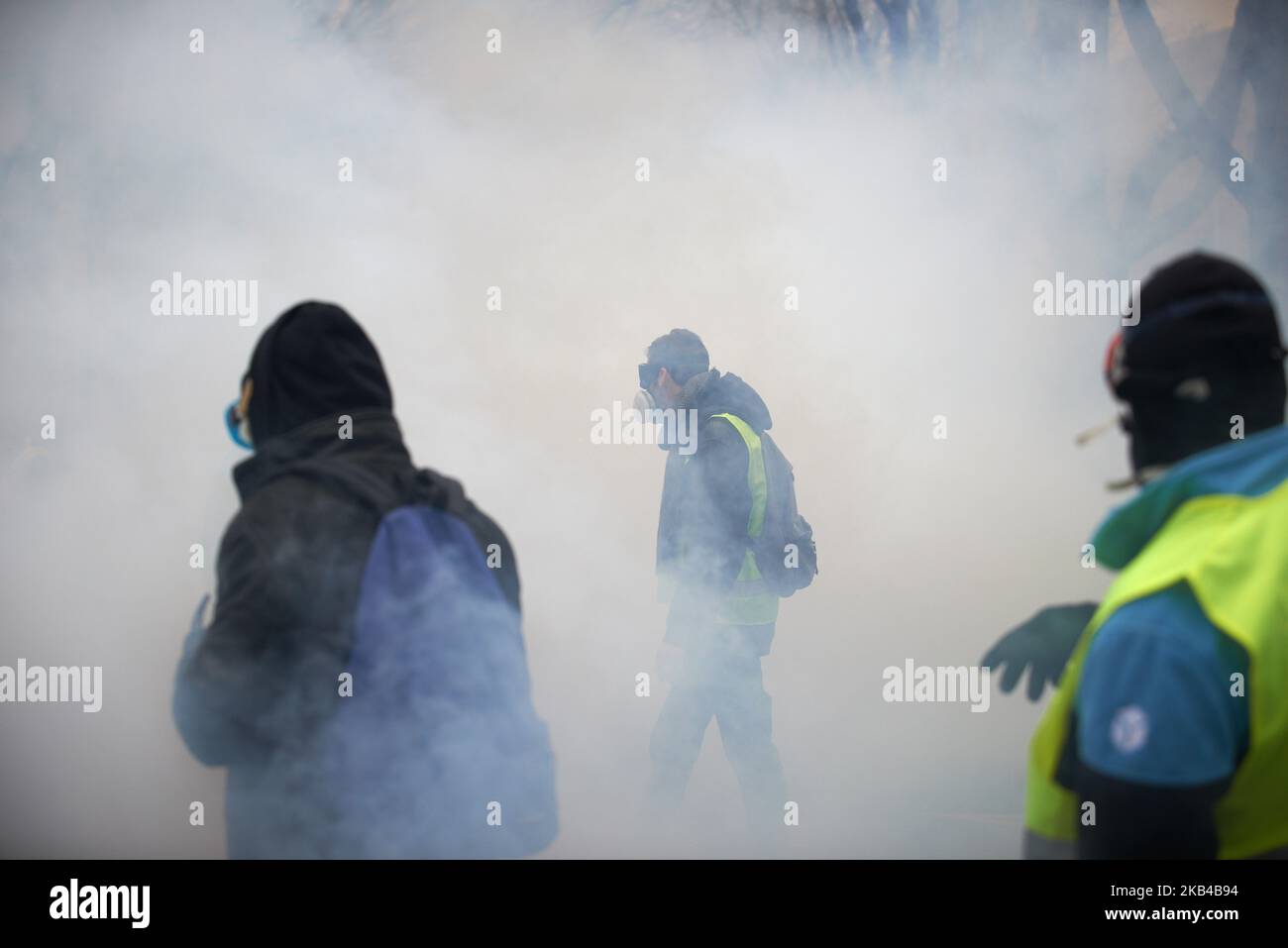 Tolosa, Francia - 29 dicembre 2018 - i manifestanti camminano tra le nuvole di gas lacrimogeno. Atto VII chiamato 'Revolution' del movimento dei gilet gialli iniziò pacificamente ma la protesta si trasformò rapidamente in rivolte per ore. La polizia antisommossa ha lanciato volley di taniche di gas lacrimogeno, ha sparato decine di giri di palline. Il movimento delle giacche gialle è iniziato il 17th novembre da una protesta contro l'aumento delle tasse sui prodotti petroliferi. (Foto di Alain Pitton/NurPhoto) Foto Stock