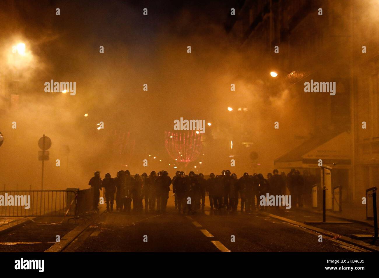 La polizia francese attraversa una nuvola di gas lacrimogeno usata per disperdere i manifestanti "gilet giallo" (Gilets jaunes) e altri in una strada laterale al largo degli Champs-Elysees dopo le celebrazioni di Capodanno nella capitale francese Parigi il 1 gennaio 2019. Un'esposizione di fuochi d'artificio e uno spettacolo di suoni e luci sotto il tema 'Fraternity' sono andati avanti sugli Champs-Elysees nonostante i piani per ulteriori proteste anti-governative 'gilet giallo' nel famoso viale. (Foto di Sameer al-Doumy/NurPhoto) Foto Stock