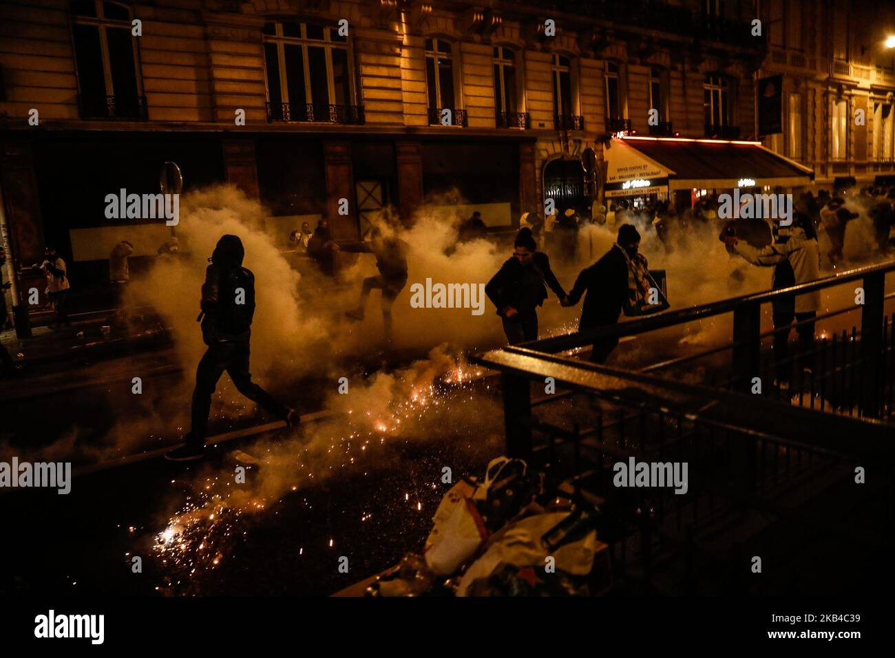 I manifestanti "gilet giallo" (Gilets jaunes) e altri corrono come polizia usano gas lacrimogeni per disperderli su una strada laterale al largo degli Champs-Elysees dopo le celebrazioni di Capodanno nella capitale francese Parigi il 1 gennaio 2019. Un'esposizione di fuochi d'artificio e uno spettacolo di suoni e luci sotto il tema 'Fraternity' sono andati avanti sugli Champs-Elysees nonostante i piani per ulteriori proteste anti-governative 'gilet giallo' nel famoso viale. (Foto di Sameer al-Doumy/NurPhoto) Foto Stock