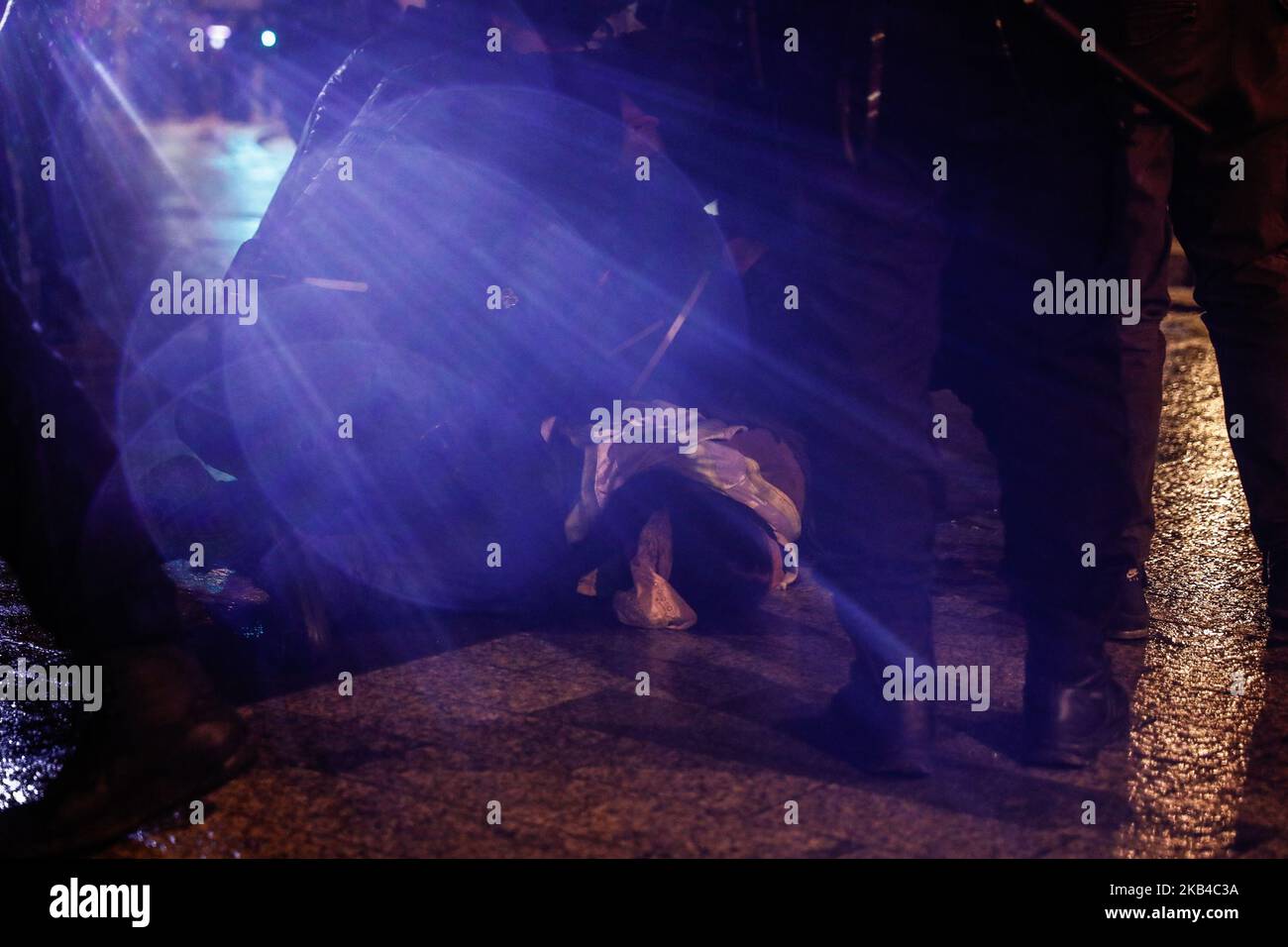 La polizia francese si trova sopra un uomo a terra e accende la torcia elettrica sulle telecamere per impedire ai giornalisti di fotografarli mentre detengono un manifestante Yellow Vests dopo aver disperso i manifestanti 'gilet giallo' (Gilets jaunes) E altri su una strada laterale fuori dagli Champs-Elysees dopo le celebrazioni di Capodanno nella capitale francese Parigi il 1 gennaio 2019. Un'esposizione di fuochi d'artificio e uno spettacolo di suoni e luci sotto il tema 'Fraternity' sono andati avanti sugli Champs-Elysees nonostante i piani per ulteriori proteste anti-governative 'gilet giallo' nel famoso viale. (Foto di Sameer al-Doumy/NurPhoto) Foto Stock