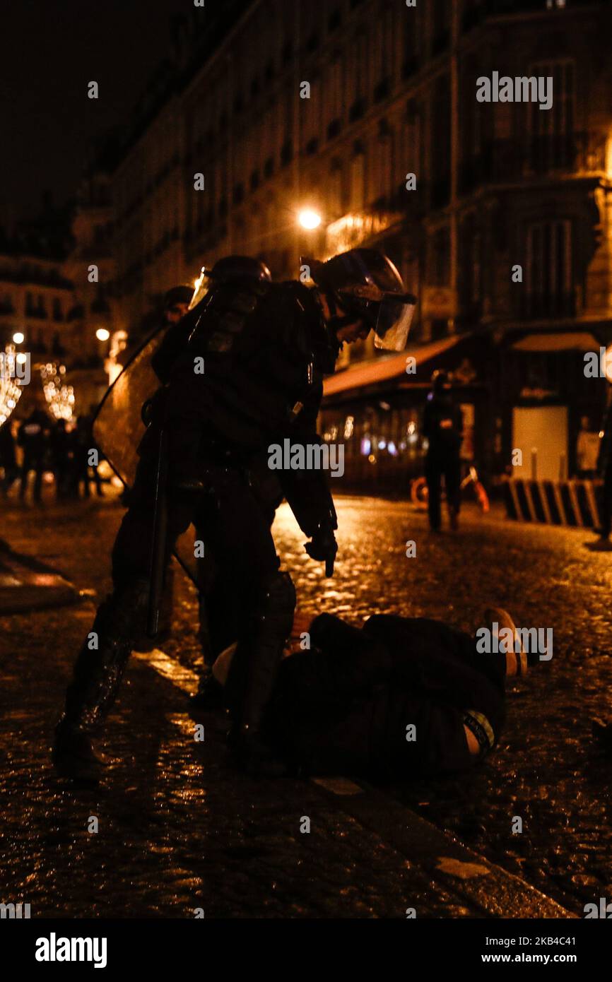 La polizia francese si trova a capo di un uomo sul terreno dopo aver disperso i manifestanti del "giubbotto giallo" (Gilets jaunes) e altri in una strada laterale al largo degli Champs-Elysees dopo le celebrazioni di Capodanno nella capitale francese Parigi il 1 gennaio 2019. Un'esposizione di fuochi d'artificio e uno spettacolo di suoni e luci sotto il tema 'Fraternity' sono andati avanti sugli Champs-Elysees nonostante i piani per ulteriori proteste anti-governative 'gilet giallo' nel famoso viale. (Foto di Sameer al-Doumy/NurPhoto) Foto Stock