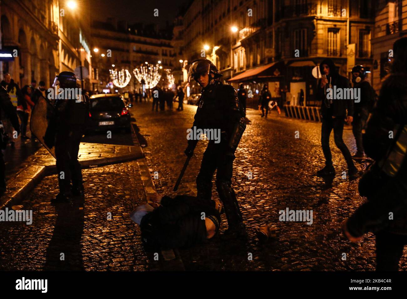 La polizia francese si trova a capo di un uomo sul terreno dopo aver disperso i manifestanti del "giubbotto giallo" (Gilets jaunes) e altri in una strada laterale al largo degli Champs-Elysees dopo le celebrazioni di Capodanno nella capitale francese Parigi il 1 gennaio 2019. Un'esposizione di fuochi d'artificio e uno spettacolo di suoni e luci sotto il tema 'Fraternity' sono andati avanti sugli Champs-Elysees nonostante i piani per ulteriori proteste anti-governative 'gilet giallo' nel famoso viale. (Foto di Sameer al-Doumy/NurPhoto) Foto Stock