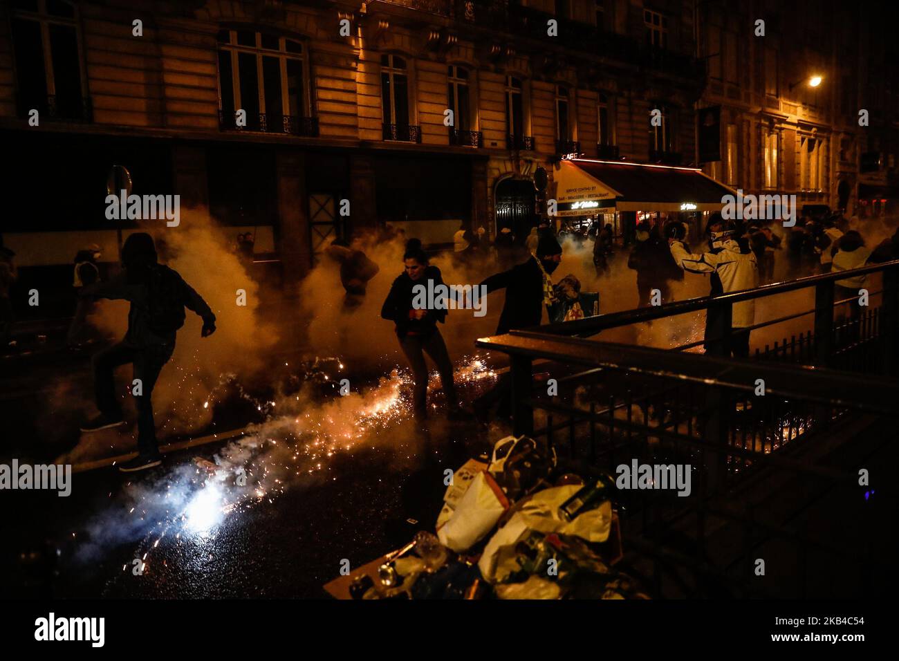 I manifestanti "gilet giallo" (Gilets jaunes) e altri corrono come polizia usano gas lacrimogeni per disperderli su una strada laterale al largo degli Champs-Elysees dopo le celebrazioni di Capodanno nella capitale francese Parigi il 1 gennaio 2019. Un'esposizione di fuochi d'artificio e uno spettacolo di suoni e luci sotto il tema 'Fraternity' sono andati avanti sugli Champs-Elysees nonostante i piani per ulteriori proteste anti-governative 'gilet giallo' nel famoso viale. (Foto di Sameer al-Doumy/NurPhoto) Foto Stock