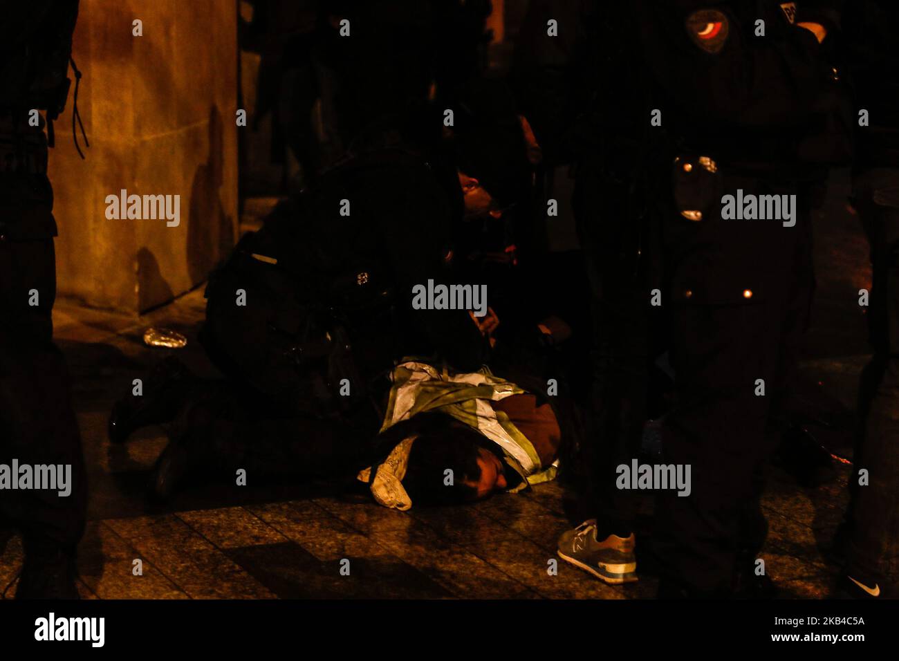 La polizia francese si trova sopra un uomo a terra e accende la torcia elettrica sulle telecamere per impedire ai giornalisti di fotografarli mentre detengono un manifestante Yellow Vests dopo aver disperso i manifestanti 'gilet giallo' (Gilets jaunes) E altri su una strada laterale fuori dagli Champs-Elysees dopo le celebrazioni di Capodanno nella capitale francese Parigi il 1 gennaio 2019. Un'esposizione di fuochi d'artificio e uno spettacolo di suoni e luci sotto il tema 'Fraternity' sono andati avanti sugli Champs-Elysees nonostante i piani per ulteriori proteste anti-governative 'gilet giallo' nel famoso viale. (Foto di Sameer al-Doumy/NurPhoto) Foto Stock