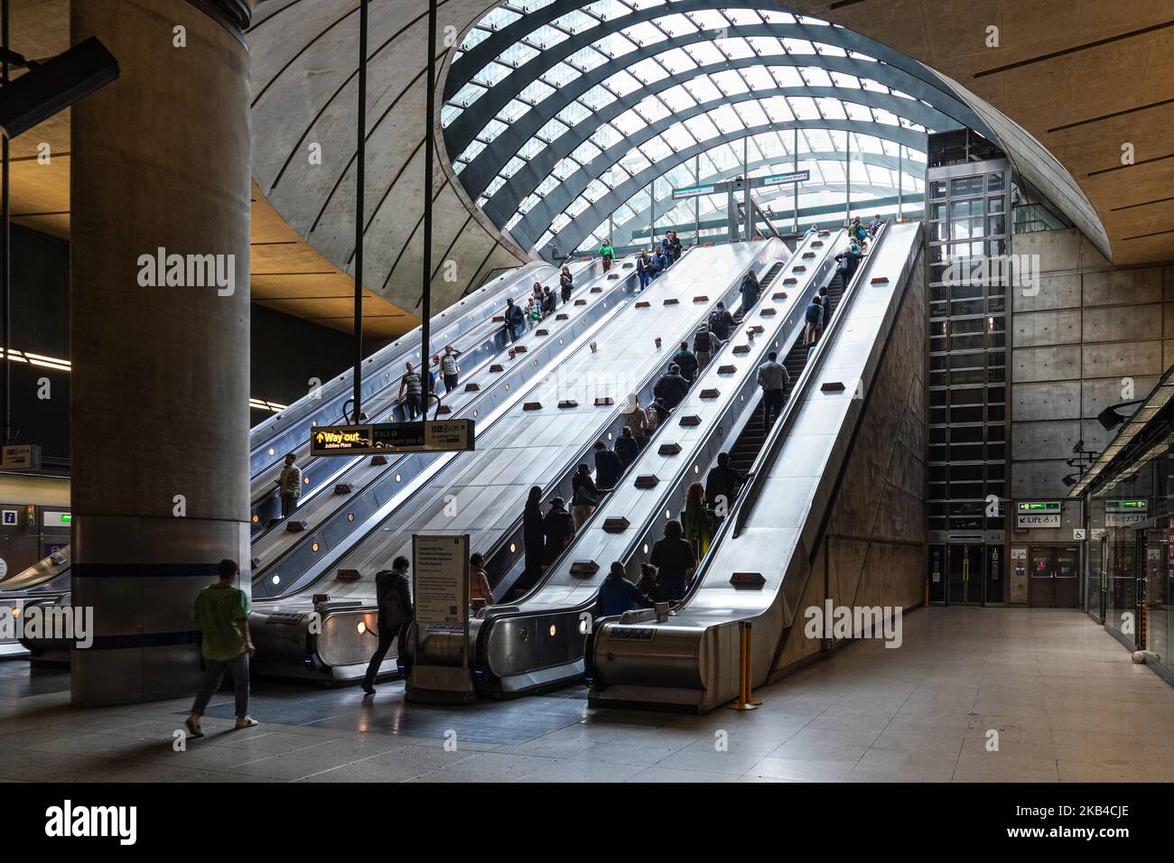 Persone su scale mobili a Canary Wharf metropolitana, stazione della metropolitana Londra Inghilterra Regno Unito Regno Unito Foto Stock