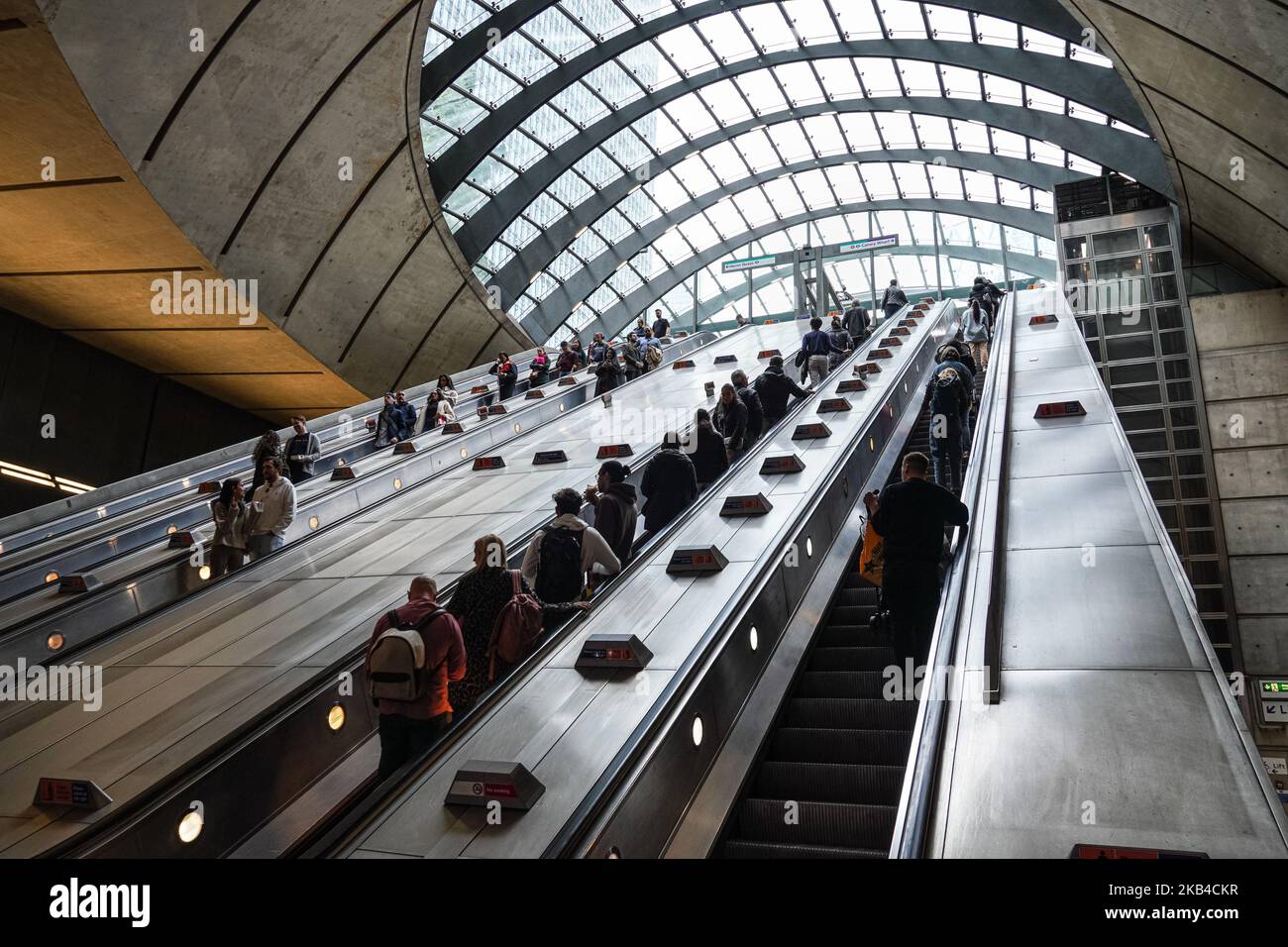Persone su scale mobili a Canary Wharf metropolitana, stazione della metropolitana Londra Inghilterra Regno Unito Regno Unito Foto Stock
