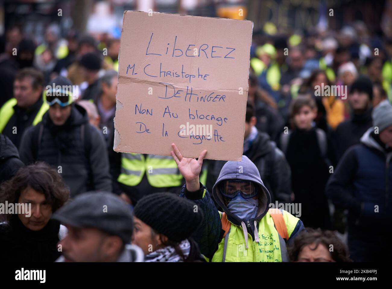 Un gilet giallo contiene un cartoncino che legge 'Christophe Dettinger libero'. Christophe Dettinger è un boxer che ha inscatolato un poliziotto tumultuato e che è in prigione. Per la legge 9 del movimento dei gilet gialli, più di dieci migliaia di persone sono scese per le strade. Al suo inizio il 17th novembre, i giubbotti gialli iniziarono con una protesta contro l'aumento delle tasse sui prodotti petroliferi. Chiedono più democrazia e il RIC (referendum avviato dai cittadini). L'aumento delle tasse è stato il detonatore della loro ira contro il presidente francese Macron e il suo governo e la loro richiesta di dimissioni. Tolosa. Francia. Janua Foto Stock