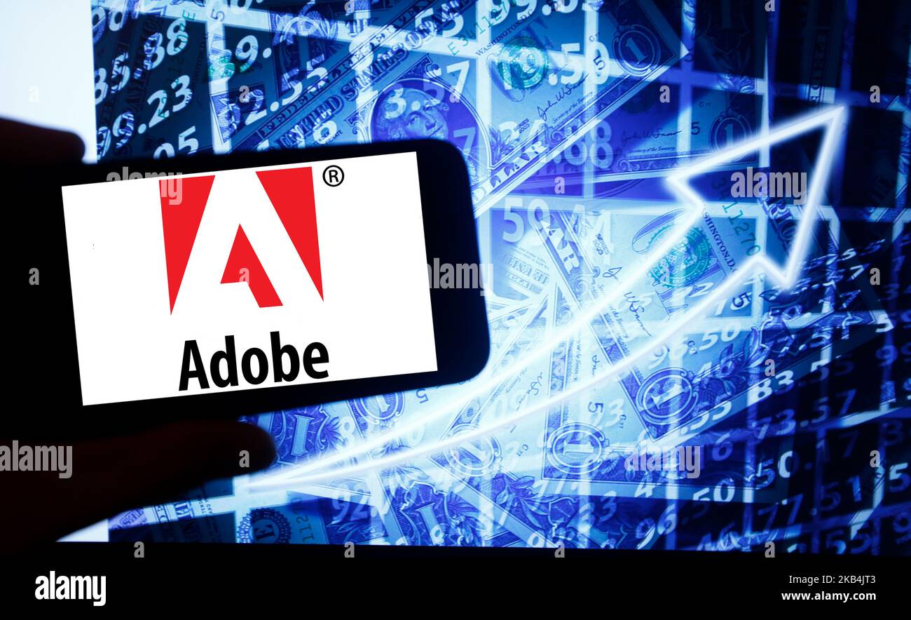 Il logo di Adobe Systems viene visualizzato su uno schermo di uno smartphone accanto a uno schermo con un'illustrazione del mercato azionario. Adobe è elencato in Nasdaq. Il Nasdaq è la seconda borsa più grande del mondo dopo la borsa di New York. (Foto di Alexander Pohl/NurPhoto) Foto Stock