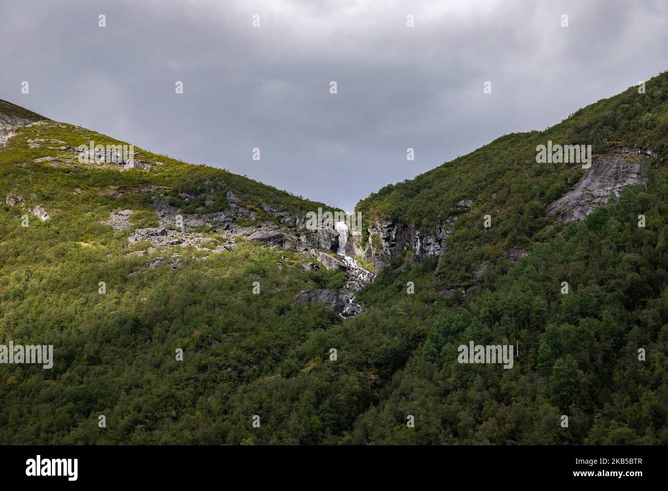 Belle cascate all'interno di natura intensa in uno scenario drammatico con nuvole o verde ambiente naturale forestale, visto ai fiordi in Norvegia con foreste e ripide montagne. Le acque provenienti dalle cime montuose e dai ghiacciai d'alta quota finiscono attraverso il fiume Valldola fino ai fiordi e al mare nella zona di Valldal e Valldalen il 31 agosto 2019. (Foto di Nicolas Economou/NurPhoto) Foto Stock