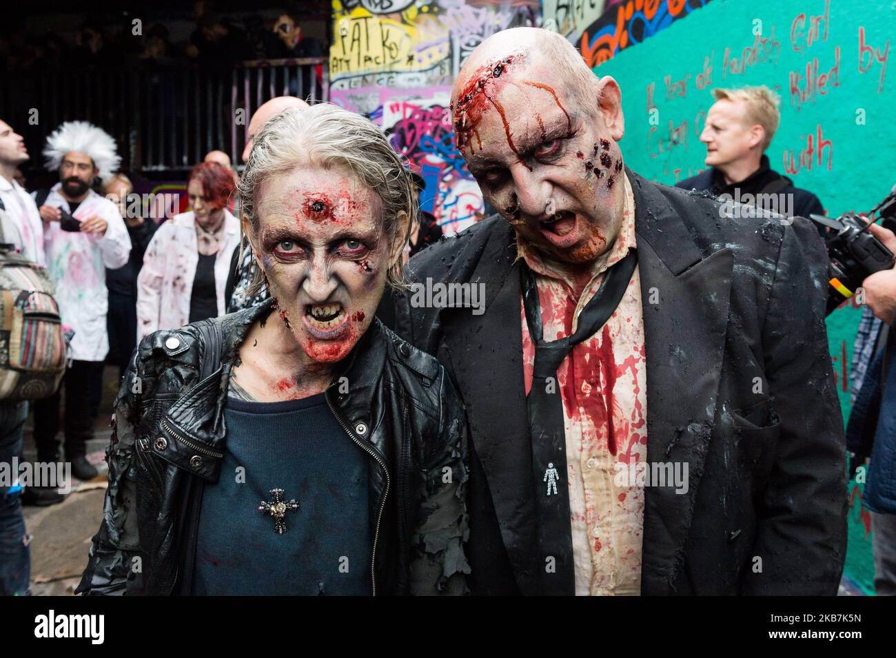 Le persone che indossano abiti eleganti posa per le foto davanti alla "passeggiata zombie" nella Giornata Mondiale dello Zombie, il 05 ottobre 2019 a Londra, Inghilterra. La Giornata Mondiale dello Zombie è una passeggiata annuale di raccolta fondi per sostenere la prevenzione della fame e dell'homelessness, con i soldi raccolti nel 2019 da donare al City Harvest London che distribuisce cibo in eccesso alle persone bisognose. (Foto di Wiktor Szymanowicz/NurPhoto) Foto Stock