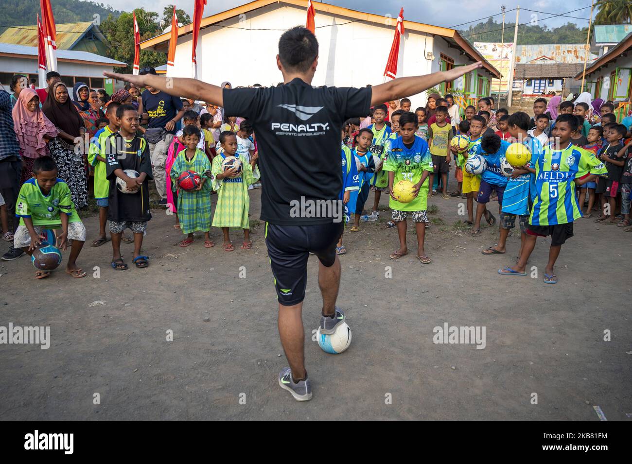 I sopravvissuti alle catastrofi si preparano a partecipare a una clinica di coaching dei giocatori di calcio del club giapponese Shonan Bellmare Go Shibuya e Ryo Kusakabe in un campo residenziale temporaneo nel campo profughi di Sumari Village, Donggala Regency, Sulawesi centrale, Indonesia, il 10 ottobre 2019. La clinica di coaching è una serie di programmi di assistenza umanitaria dal club di calcio giapponese alle vittime del terremoto, dello tsunami e della liquefazione nel Sulawesi centrale, facilitati da Peace Winds Japan (PWJ) e Quick Action Response (ACT) Indonesia. La clinica istruente è inoltre uno sforzo curare il trauma sperimentato vicino Foto Stock