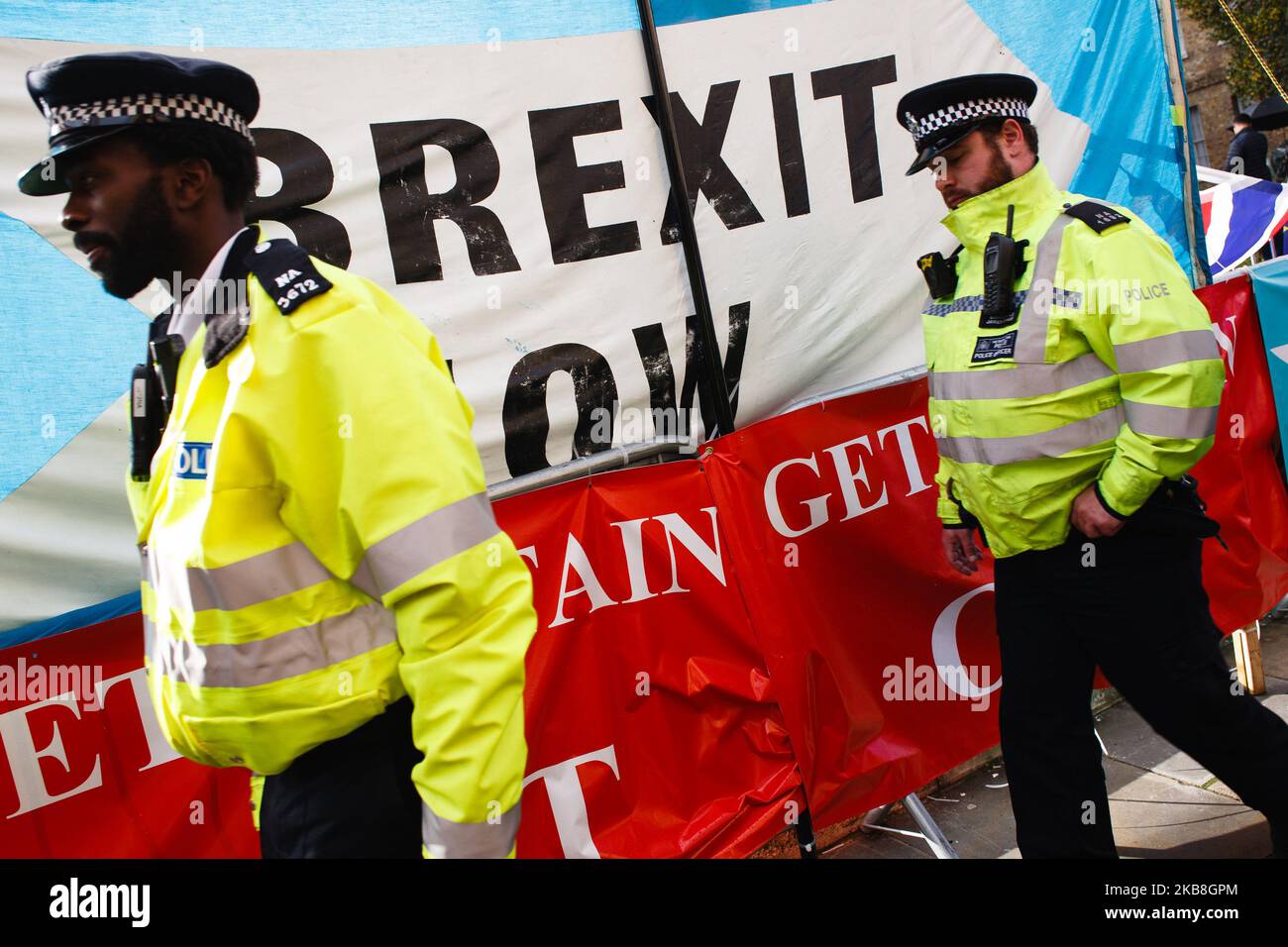 I poliziotti passano davanti a una bandiera del Partito Brexit su Abingdon Street fuori dal Parlamento di Londra, Inghilterra, il 17 ottobre 2019. Il primo ministro Boris Johnson ha concordato oggi un nuovo accordo di ritiro con l'Unione europea, ma non è chiaro se l'accordo passerà un voto sui beni comuni fissato per questo sabato, in una sessione speciale del fine settimana dei parlamentari. Il Partito democratico Unionista (DUP), visto come un influente sostenitore di una sciata di deputati del Partito conservatore pro-Brexit, ha detto senza senso di non sostenere l’accordo. (Foto di David Cliff/NurPhoto) Foto Stock