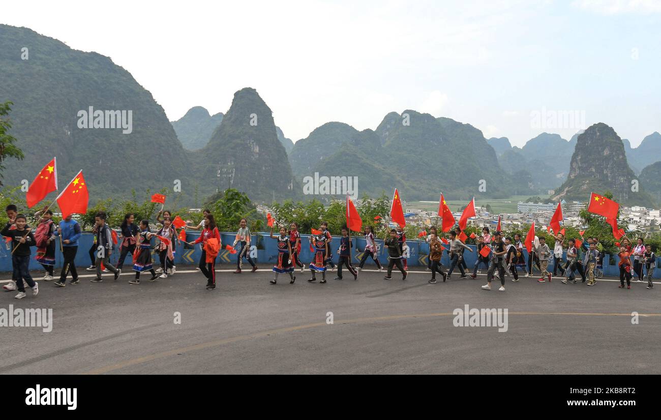 I bambini delle scuole locali, principalmente di etnia Zhuang, sono in arrivo alla quarta tappa, Nanning to Nongla, dell'edizione 3rd del Cycling Tour de Guangxi 2019. Domenica 20 ottobre 2019, nella zona panoramica di Nongla, nella contea di Mashan, nella regione di Guangxi, Cina. (Foto di Artur Widak/NurPhoto) Foto Stock