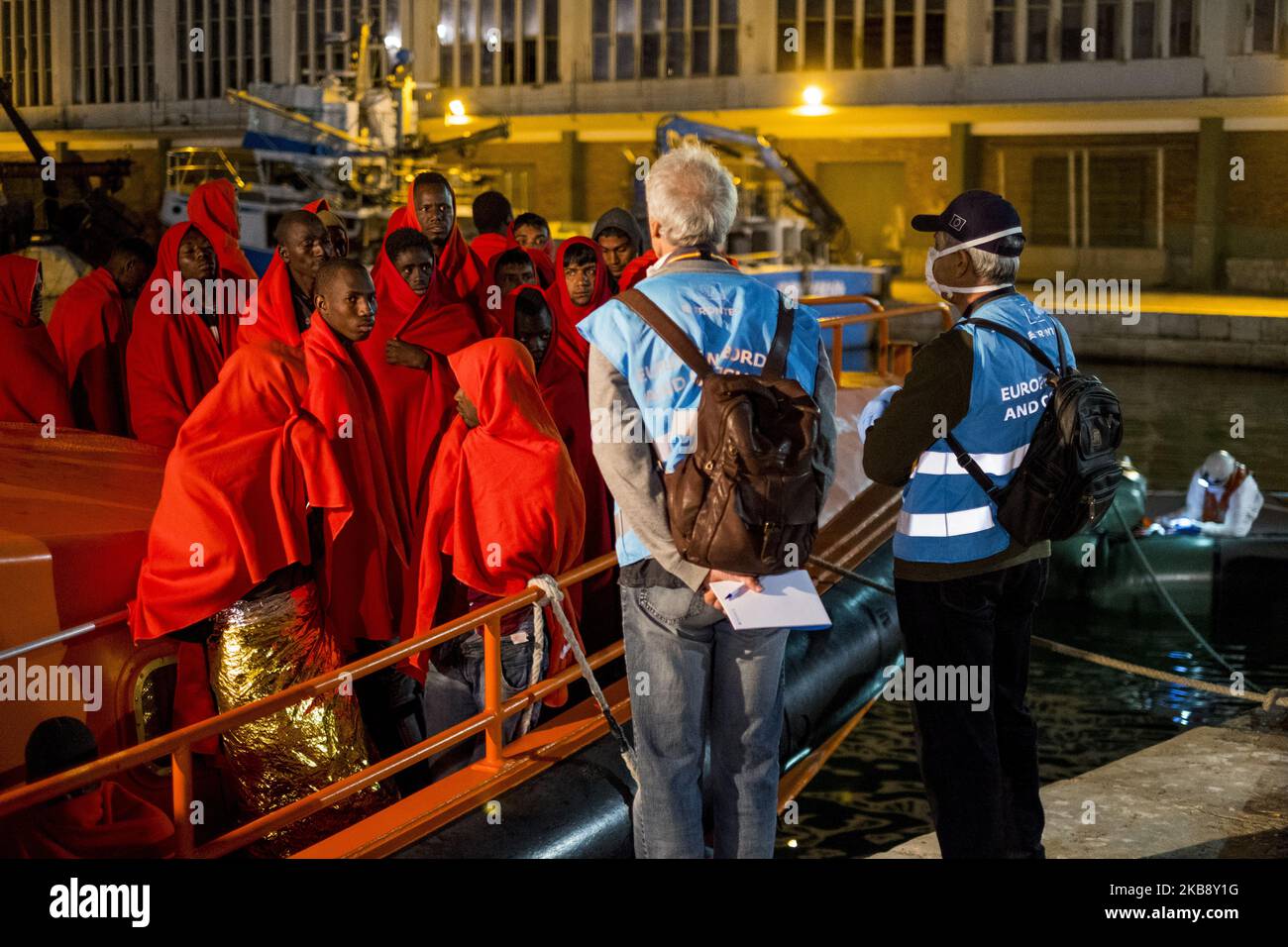 Due membri del personale di Frontex pongono domande ai migranti salvati nel porto di Malaga, a Malaga, in Spagna, il 21 ottobre 2019. (Foto di Guillaume Pinon/NurPhoto) Foto Stock