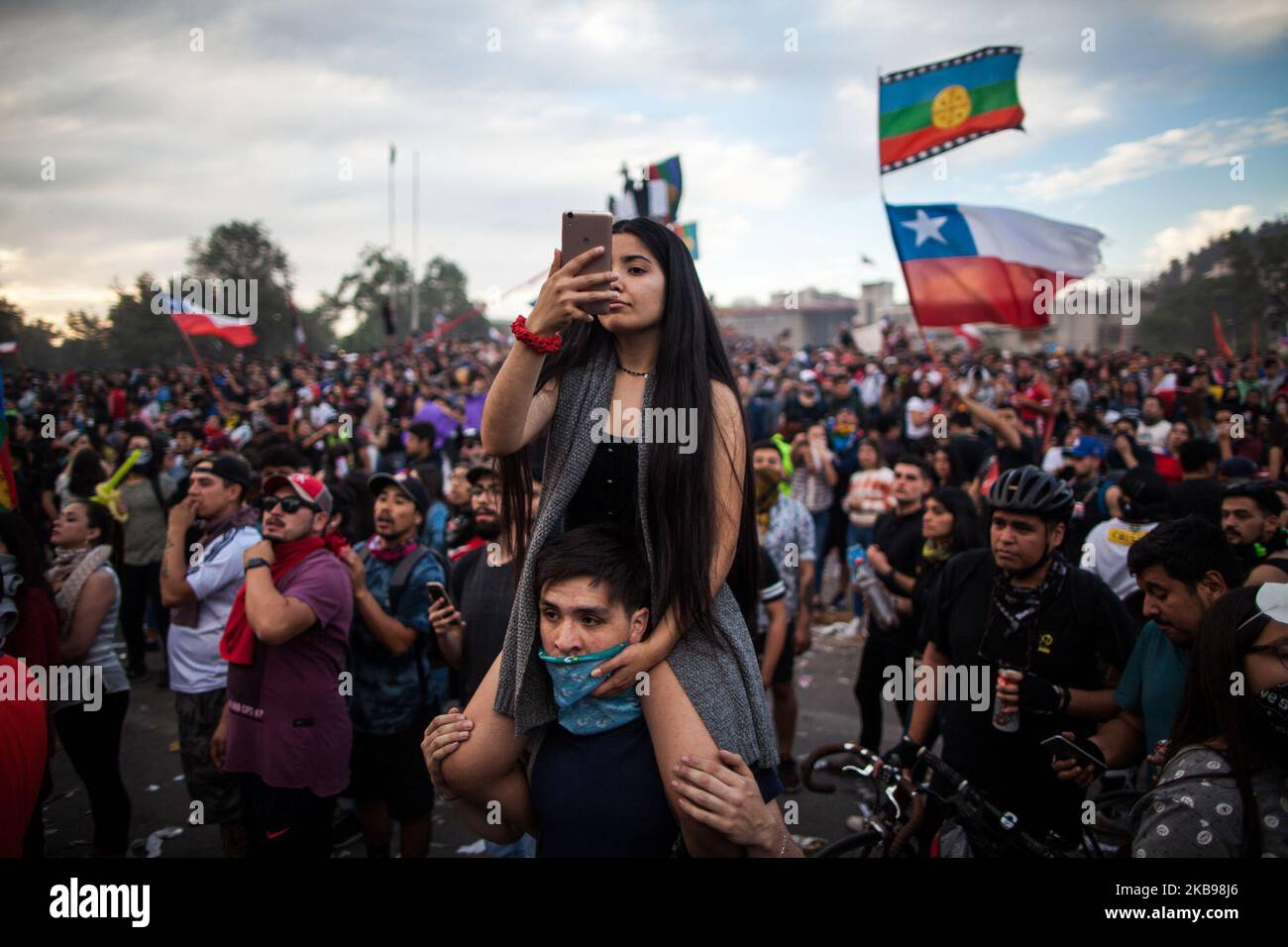 Una donna registra con il suo telefono tutte le persone riunite in Plaza Italia, il 25 ottobre 2019, a Santiago, Cile, Durante l'ottavo giorno di proteste contro il governo del presidente Sebastian Pinera. Il presidente Sebastian Pinera ha annunciato misure per migliorare la disuguaglianza sociale, tuttavia i sindacati hanno chiesto uno sciopero a livello nazionale e le dimostrazioni massicce continuano quando il numero delle vittime raggiunge i 18. Tra le richieste che hanno suscitato le proteste vi sono: Assistenza sanitaria, sistema pensionistico, privatizzazione dell'acqua, trasporti pubblici, istruzione, mobilità sociale e corruzione. (Foto di Javier Barrera/NurPhoto) Foto Stock