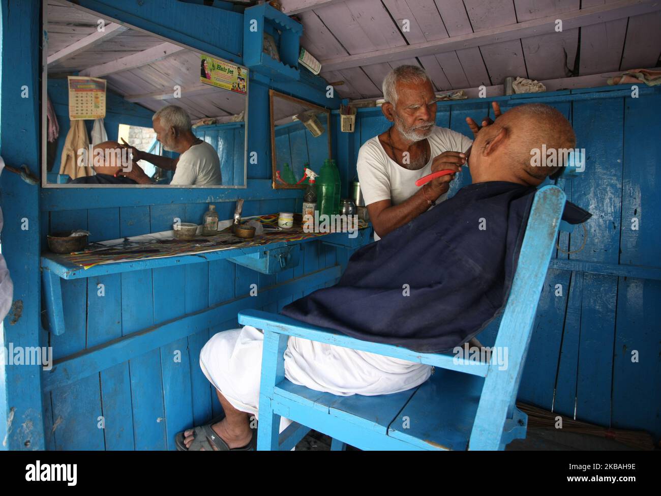 Un barbiere rasa la barba ad un devoto nel suo negozio, un giorno dopo il verdetto della Corte Suprema su un sito religioso contestato, ad Ayodhya, India, 10 novembre 2019. Gli indù otterranno l'intero 2,77 acri disputati in Ayodhya, SC ha regolato 9 anni dopo la sentenza Allahabad HC. I musulmani otterranno la terra alternativa o nell'eccedenza 67 acri acquisiti dal govt centrale intorno alla struttura disputata o in un altro posto prominente. (Foto di Ritesh Shukla ) (Foto di Ritesh Shukla/NurPhoto) Foto Stock