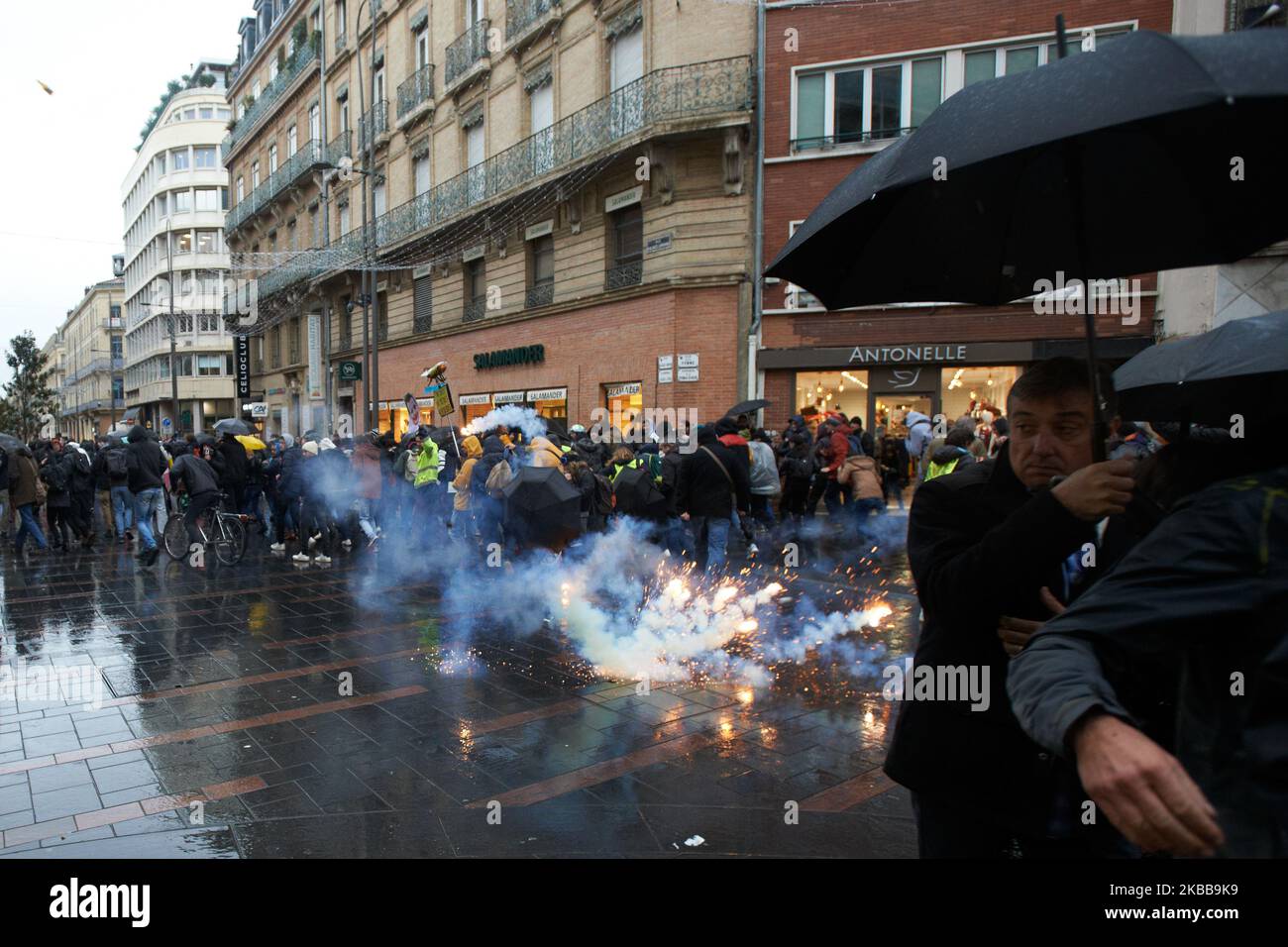 Le persone scappare da una granata di gas lacrimogeni che esplode. I manifestanti di Yellow Vests hanno dimostrato per la 53th settimana consecutiva per celebrare il primo anniversario del movimento "gilet giallo" (gilet jaunes). I Tthey stanno progettando una serie di manifestazioni a livello nazionale questo fine settimana per mostrare al governo che possono ancora raccogliere il sostegno al primo anniversario del loro movimento. Diverse migliaia di manifestanti sono scesi per le strade di Tolosa. Ma la protesta pacifica è arrivata ad un'improvvisa fine come la polizia tumulto e Gendarmerie Mobile (militare) ha sparato cannone d'acqua e volley sparato taniche di gas lacrimogeno fino alla fine del Foto Stock
