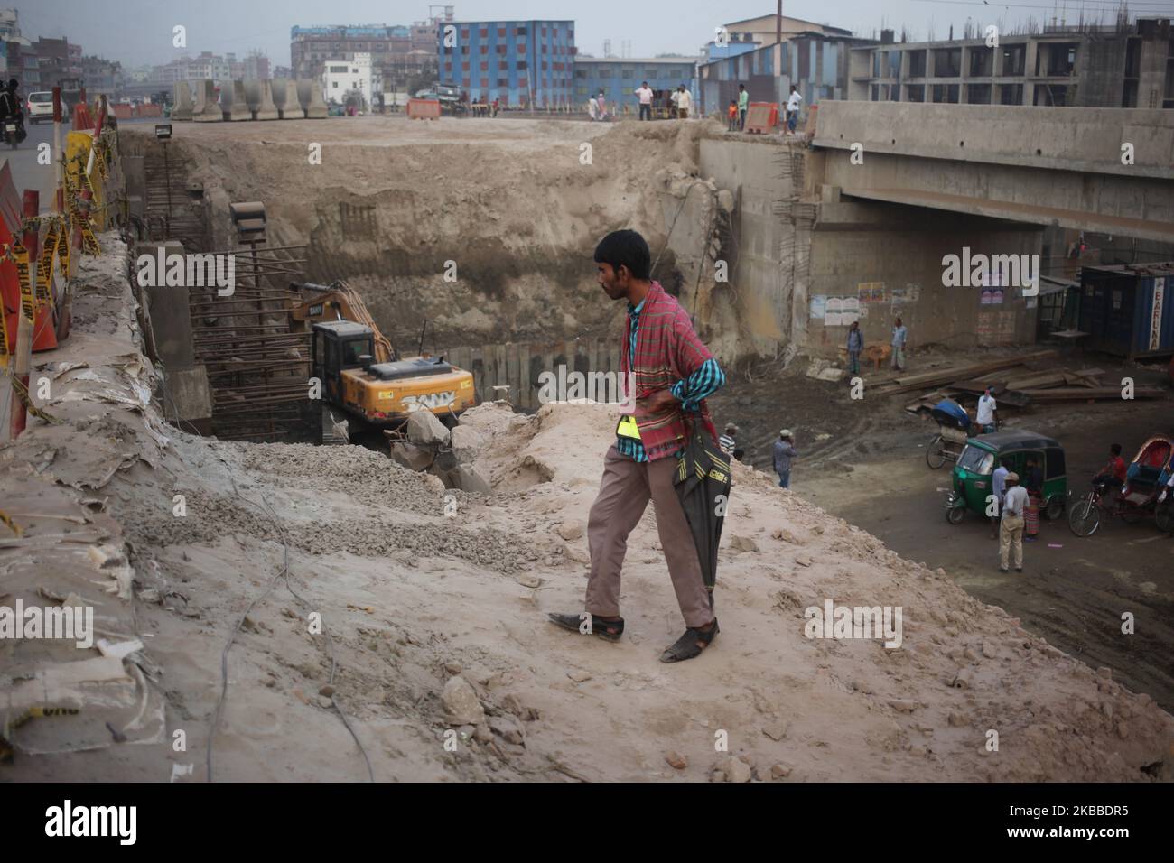 Un uomo si muove attraverso una strada in costruzione a Dhaka, Bangladesh, il 23 novembre 2019. L'aria condizionata della città di Dhaka sta peggiorando giorno per giorno ad un ritmo allarmante per gli ultimi 2 anni a causa delle nuove costruzioni stradali in gran parte della città. (Foto di Syed Mahamudur Rahman/NurPhoto) Foto Stock