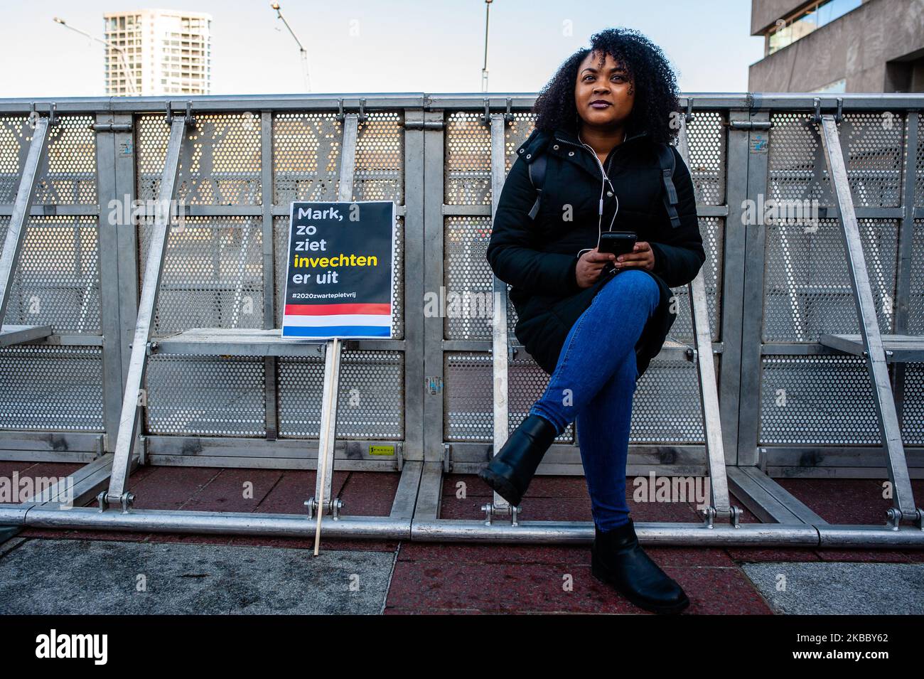 Una donna nera è seduta accanto ad uno dei cartelloni, prima che il rally Anti Black Piet iniziato a Eindhoven, il 30th novembre 2019. (Foto di Romy Arroyo Fernandez/NurPhoto) Foto Stock