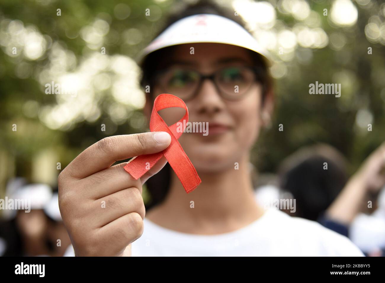 Uno studente mostra un nastro rosso durante un programma di sensibilizzazione sulla Giornata Mondiale contro l'AIDS, a Guwahati, Assam, India, domenica 1 dicembre, 2019. (Foto di David Talukdar/NurPhoto) Foto Stock