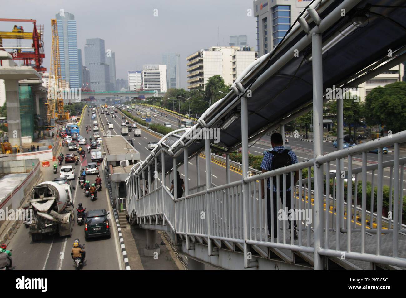 Cittadino che cammina sul ponte pedonale vicino al sito del progetto LRT Jakarta mercoledì mattina, 4 dicembre 2019. Sulla base di un rapporto di aggiornamento economico dell'ottobre 2019, la Banca mondiale prevede che la crescita economica dell'Indonesia nel 2019 raggiungerà solo il 5%, mentre il governo indonesiano è ottimista sul fatto che la crescita economica raggiungerà il 5,1%. Ciò è stato influenzato dai settori degli investimenti e dell’export che hanno rallentato a causa della guerra commerciale USA-Cina che ha causato incertezza economica globale. (Foto di Aditya Irawan/NurPhoto) Foto Stock