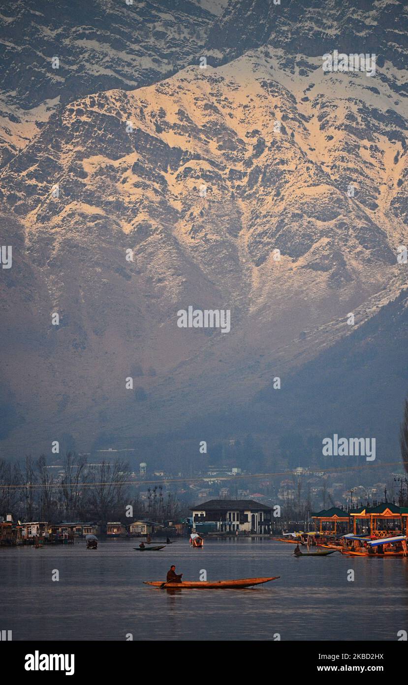 Un uomo rema la sua barca come Srinagar testimoni un tempo soleggiato il 16 dicembre 2019. Le operazioni di volo all'aeroporto di Srinagar hanno ripreso dopo essere rimasto sospeso per più di sei giorni come la neve pesante ha colpito Kashmir. (Foto di Faisal Khan/NurPhoto) Foto Stock