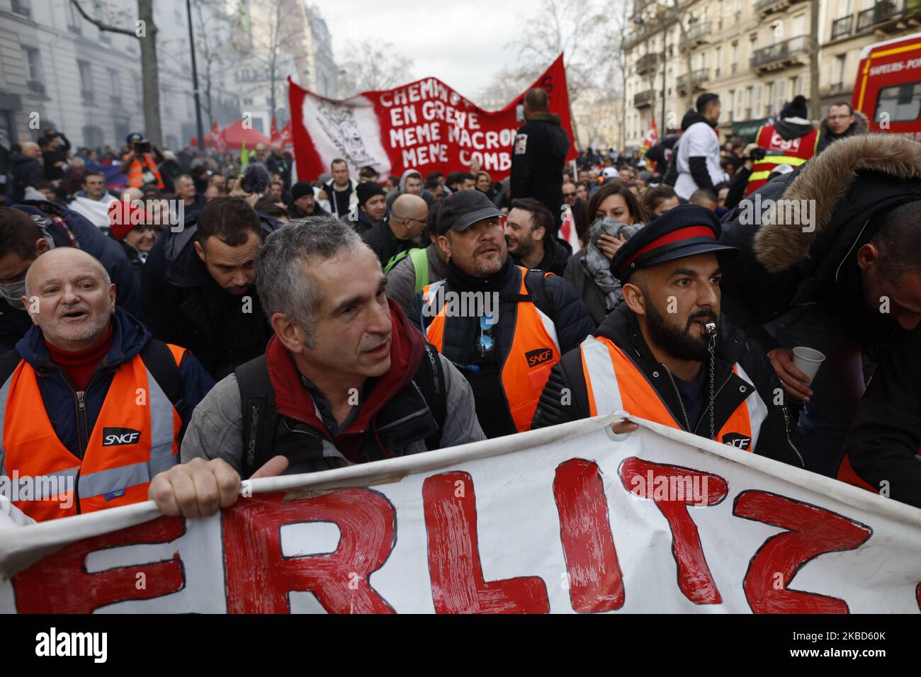 I manifestanti urlano slogan mentre tengono una bandiera durante una manifestazione per protestare contro il piano del governo francese di rivedere il sistema pensionistico del paese, come parte di uno sciopero generale nazionale a Parigi, il 17 dicembre 2019. Il 17 dicembre decine di migliaia di manifestanti stanno attraversando la Francia per una revisione delle pensioni che ha innescato uno sciopero paralizzante sui trasporti, anche se i funzionari governativi insistono che non si arresteranno alle richieste sindacali che abbandonano il piano. La pressione sul presidente francese è in aumento dopo che il top ufficiale che sovrintende ai negoziati sulle pensioni è stato costretto a dimettersi Foto Stock