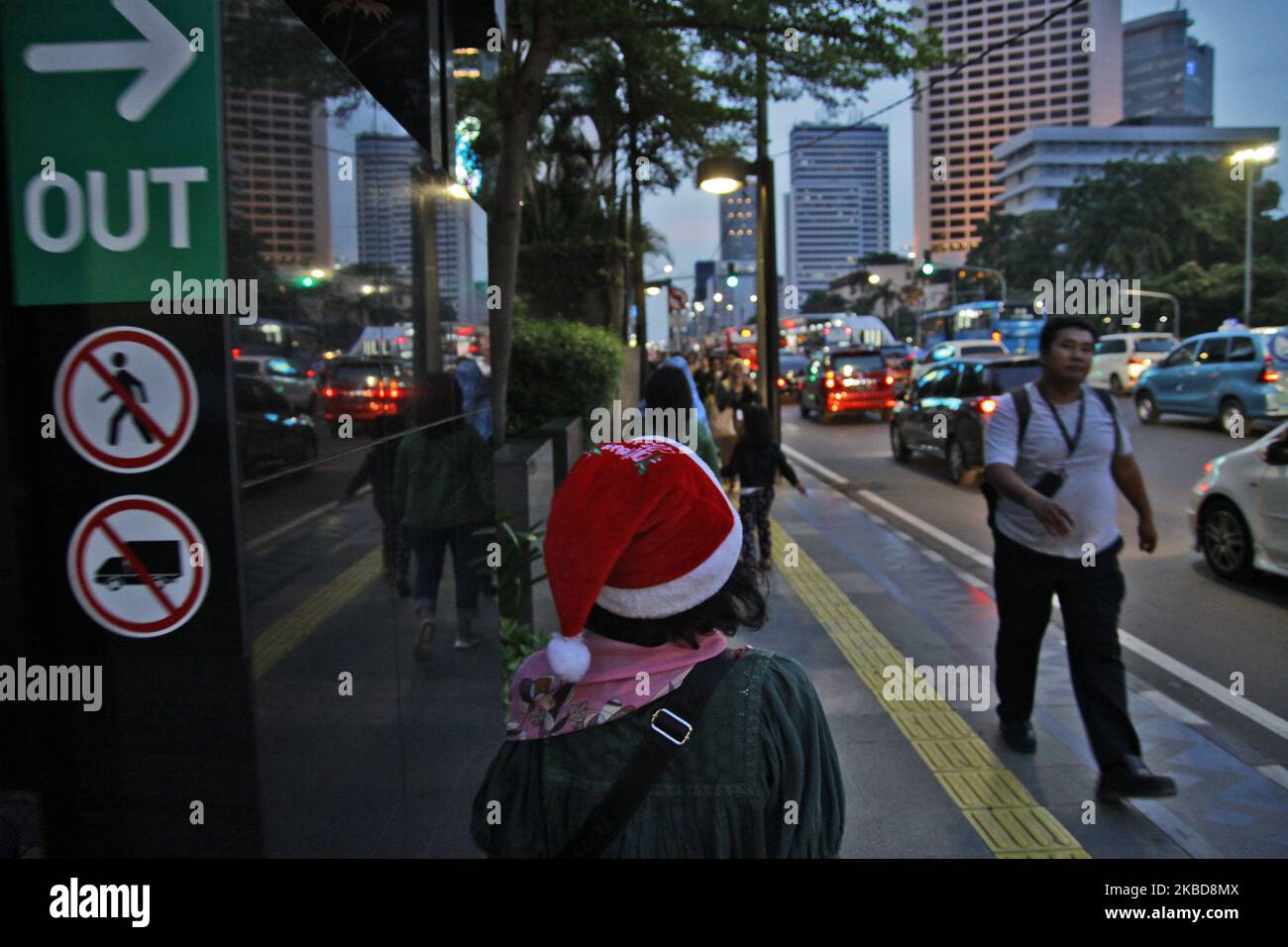 Una donna che indossa il cappello di Babbo Natale cammina sul marciapiede di Giacarta, giovedì 19 dicembre 2019. I cristiani in Indonesia e nel mondo celebreranno il 2019° giorno di Natale mercoledì 25th dicembre. (Foto di Aditya Irawan/NurPhoto) Foto Stock