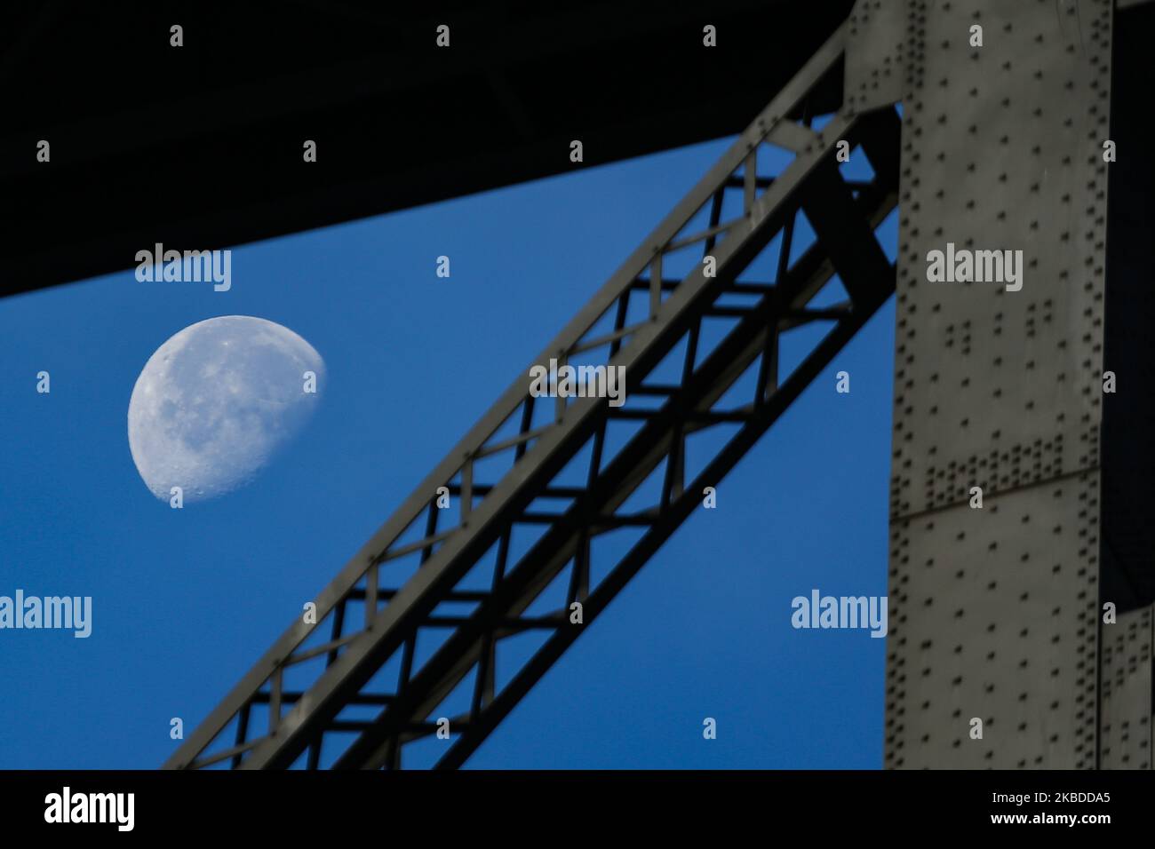 La luna attraversa il Williamsburg Bridge, un ponte sospeso a New York City attraverso l'East River, che collega la Lower East Manhattan con il quartiere di Williamsburg a Brooklyn, a Broadway. La Luna illuminante, satellite naturale della terra in orbita, come si vede nella fase gibbosa in declino, calendario lunare, con il 76% visibile. NYC, USA - 17 novembre 2019 (Foto di Nicolas Economou/NurPhoto) Foto Stock