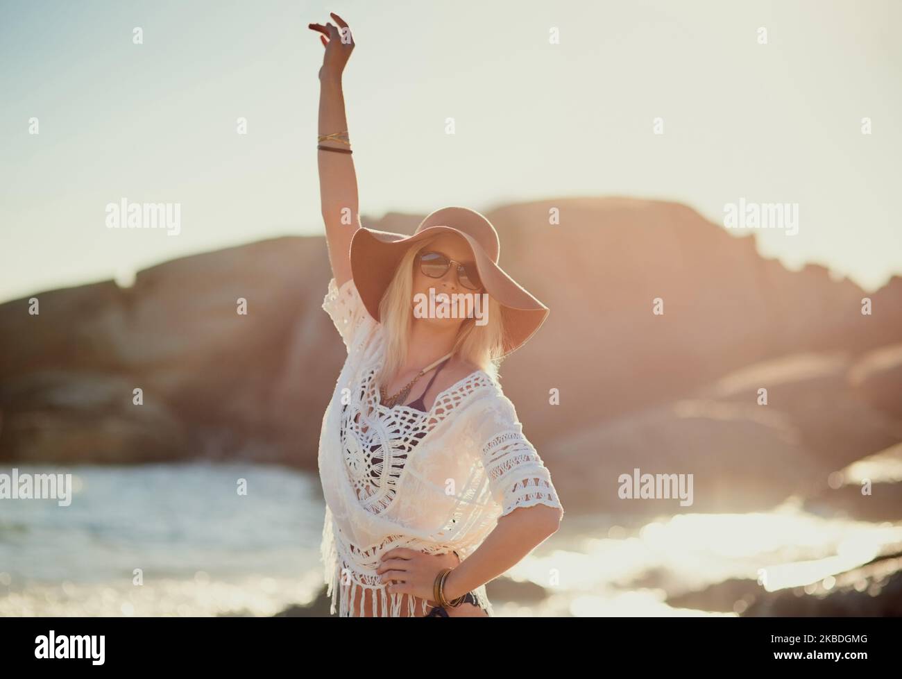 Lascia Divertiti. una giovane donna sulla spiaggia con la mano in aria. Foto Stock