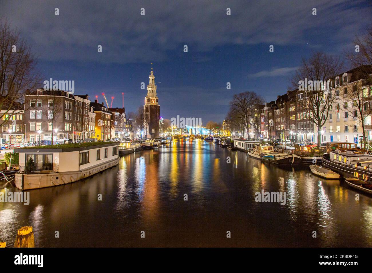 I canali di Amsterdam come Amstel, con la tipica architettura tradizionale olandese, ospitano case illuminate e case galleggianti la sera e la notte con splendidi riflessi sull'acqua e luci della città, Olanda, Olanda. Amsterdam è un centro finanziario, ma anche una delle città più visitate d'Europa, che attrae milioni di turisti in tutto il mondo, con il turismo che svolge un ruolo significativo nell'economia locale nonostante le voci che si oppongono a questo sviluppo turistico. (Foto di Nicolas Economou/NurPhoto) Foto Stock