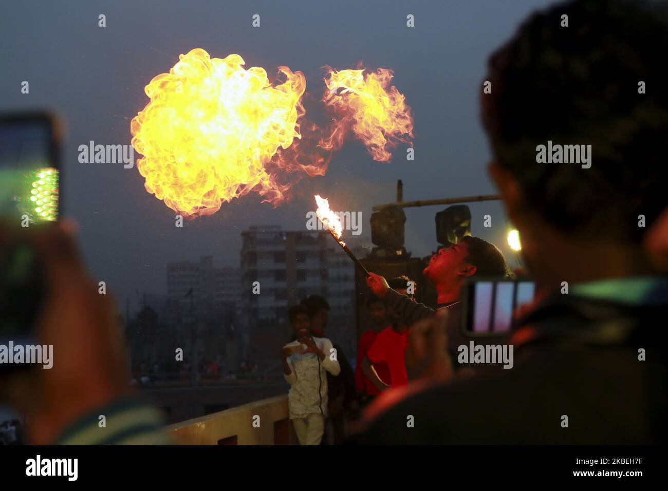 La gente del vecchio Dhaka sta giocando la spaccatura del fuoco usando l'olio di kerosene sulla cima del tetto del loro edificio in occasione del festival di Shakrain a Dhaka bangladesh il 14 gennaio 2019. Il Festival Shakrain si è svolto nella zona di Gandaria, nella vecchia città di Dhaka. Shakrain Festival, conosciuto anche come Kite Festival, si celebra in Bangladesh alla fine del mese di Bangla Poush. Shakrain Festival è uno dei più vecchi, famosi e importanti festival annuali in Bangladesh. È il simbolo dell'unità e dell'amicizia in Bangladesh. Shakrain Festival è importante soprattutto per volare un sacco di aquiloni colorati, fuoco Foto Stock