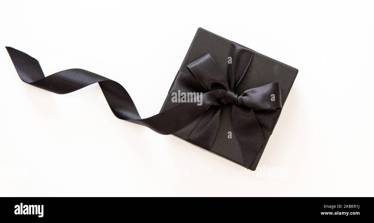 Vendita Black Friday e regali di Natale concept. Confezione regalo con nastro nero isolato su sfondo bianco, Foto Stock
