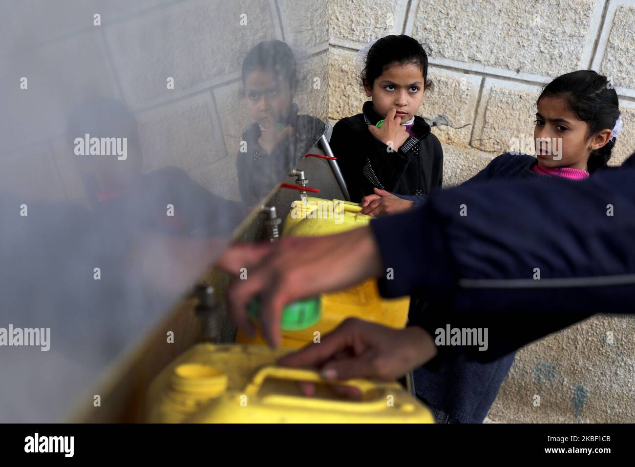 I bambini palestinesi riempiono le jerrican con acqua potabile proveniente da rubinetti pubblici durante il tempo tempestoso del campo di al-Shati per i rifugiati palestinesi a Gaza City, il 20 gennaio 2020. (Foto di Majdi Fathi/NurPhoto) Foto Stock