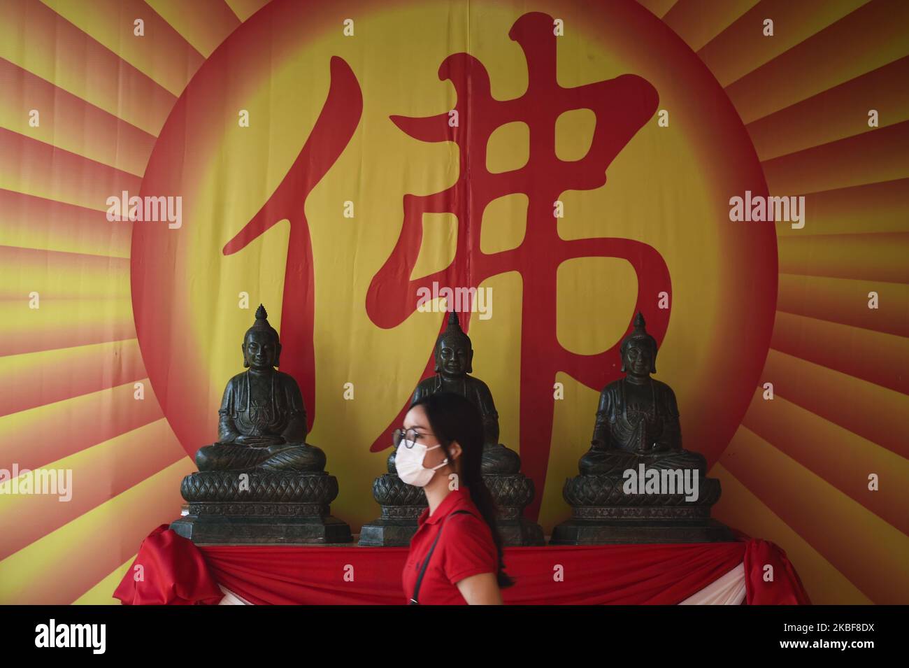 Una donna cammina di fronte ad una statua buddista durante le celebrazioni lunari del Capodanno al Wat Mangkon Kamalawat a Chinatown, Bangkok , Thailandia, 24 gennaio 2020. (Foto di Anusak Laowilas/NurPhoto) Foto Stock