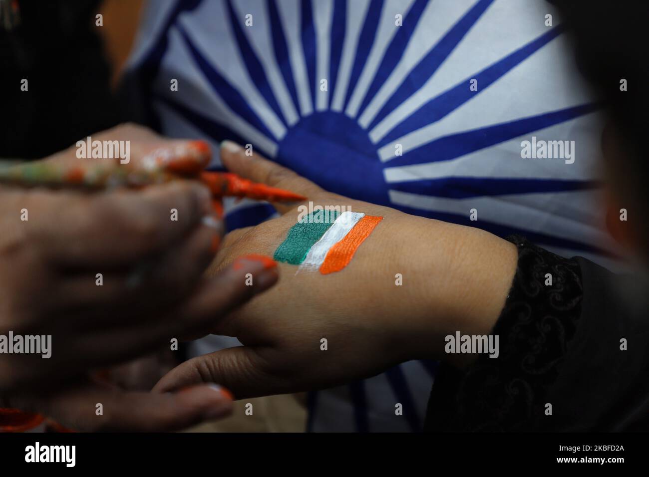 Un artista dipinge la bandiera nazionale indiana (Tri-Color) sulla mano di un dimostrante nella zona di Jamia a Nuova Delhi, India il 26 gennaio 2020. In India continuano le proteste contro la Citizenship Amendment Act (CAA) e il NPR. (Foto di Nasir Kachroo/NurPhoto) Foto Stock