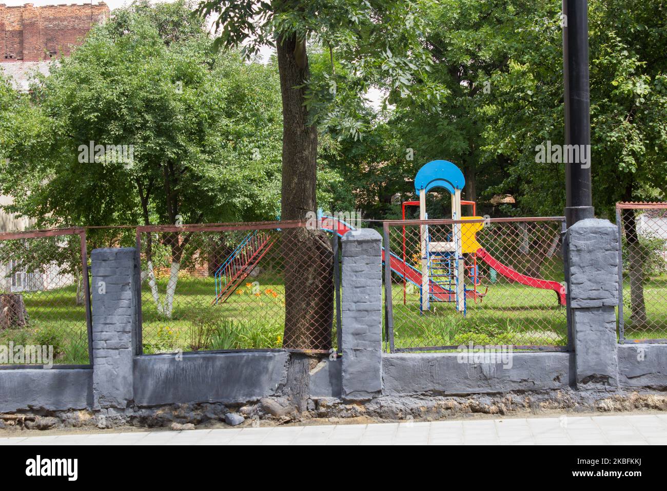 parco giochi vuoto dietro la recinzione in asilo Foto Stock