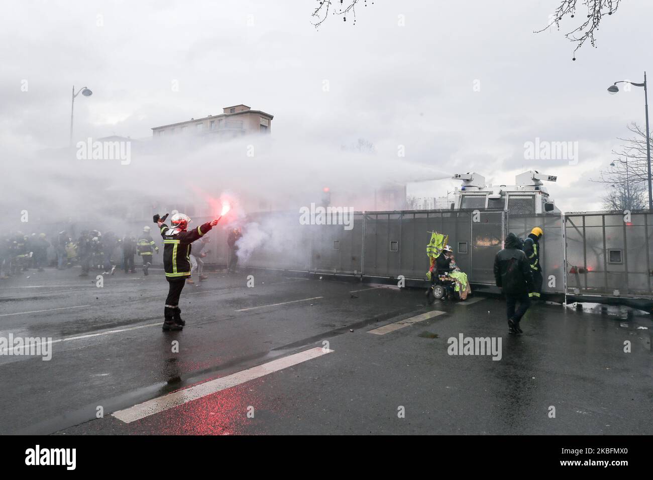 Un vigile del fuoco si trova di fronte ai canoni dell'acqua durante una manifestazione per protestare contro il piano del governo francese di rivedere il sistema pensionistico del paese a Parigi, il 28 gennaio 2020. (Foto di Michel Stoupak/NurPhoto) Foto Stock