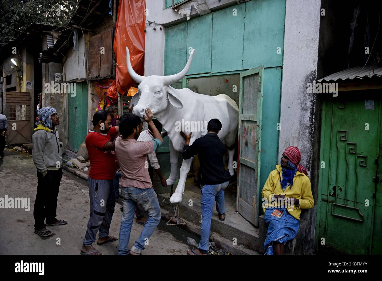 Un gruppo di uomini spinge una statua di toro in gesso di parigi in un laboratorio a Kolkata, India, 28 gennaio 2020. (Foto di Indranil Aditya/NurPhoto) Foto Stock