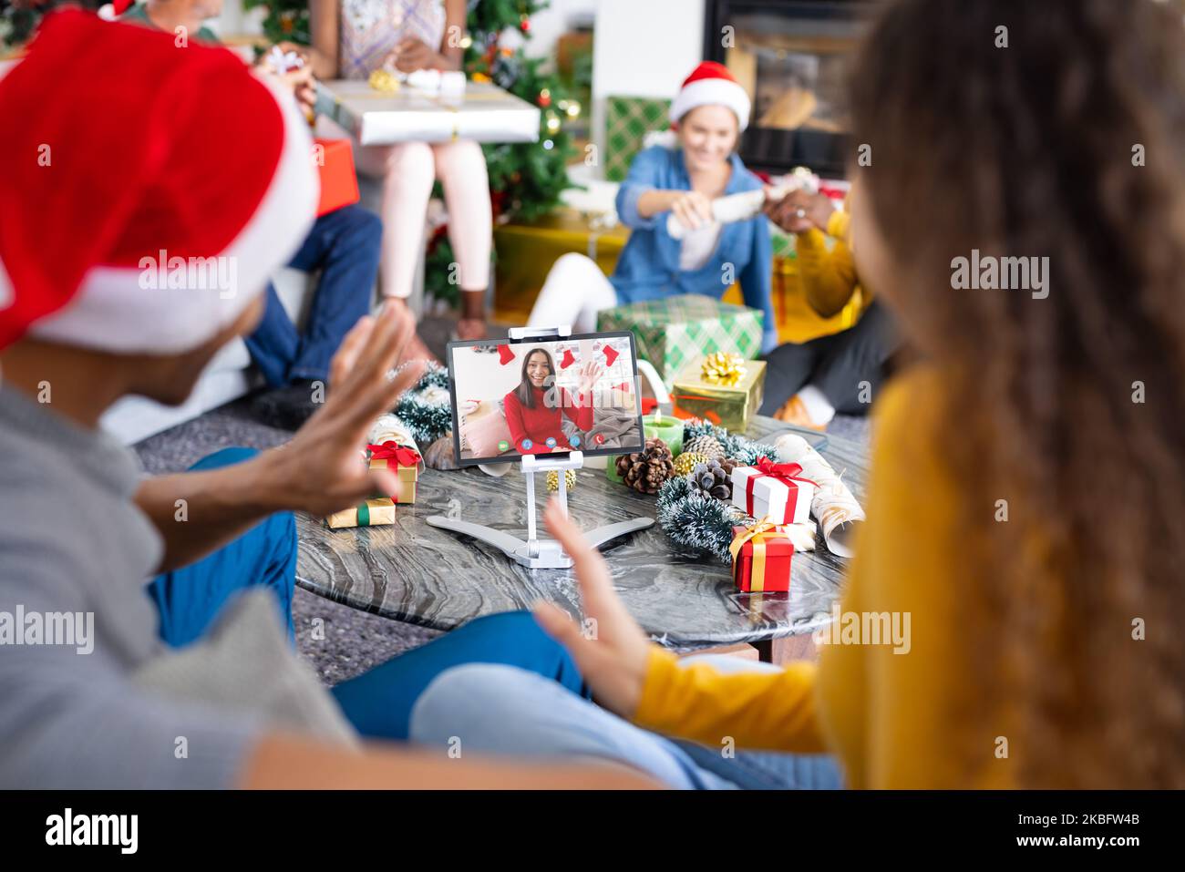 Diversi gruppi di amici che hanno la videochiamata di natale con la donna biracial Foto Stock