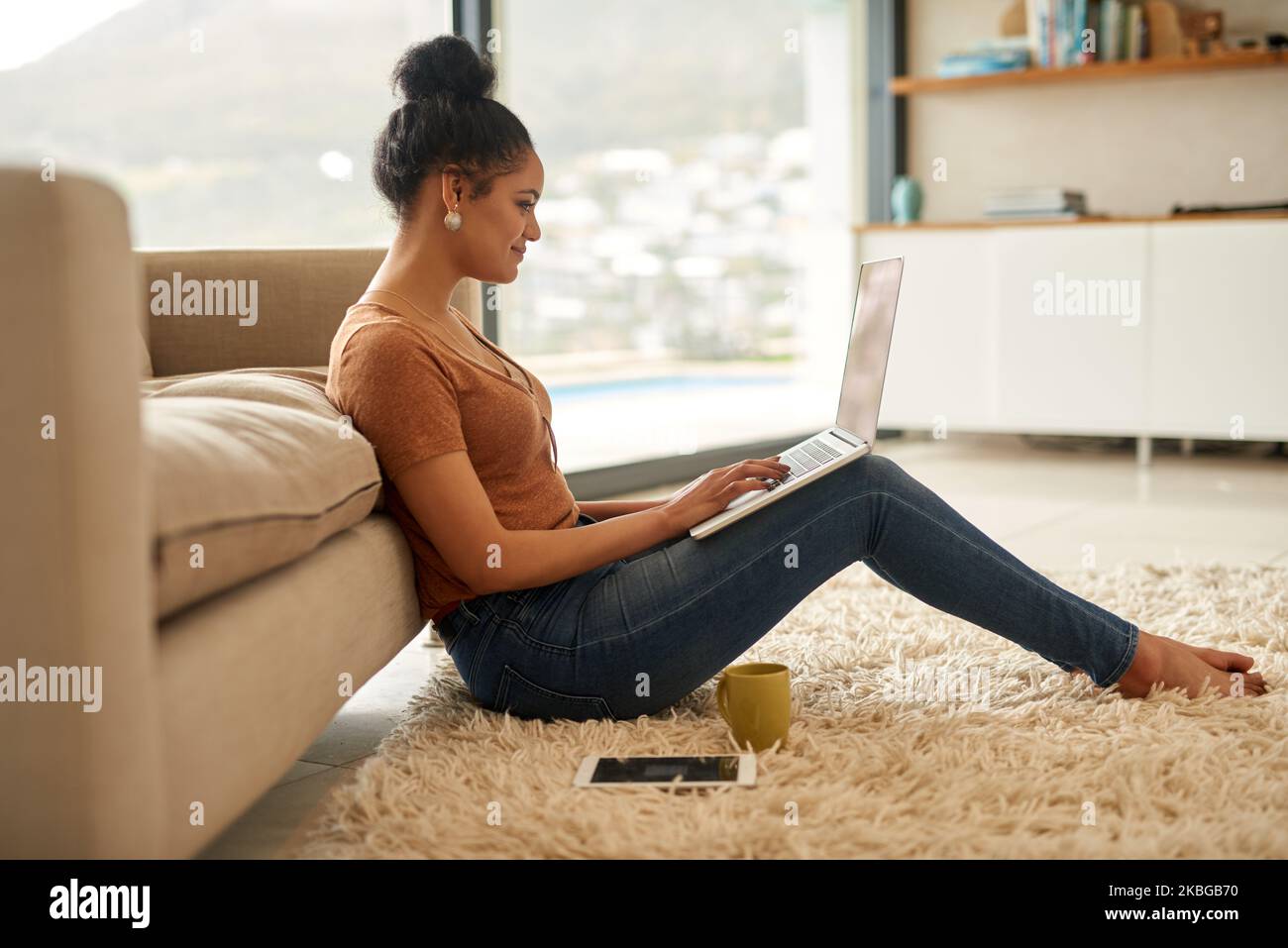 Completa il relax quando ho il wifi e il mio portatile. Una giovane donna che usa un portatile a casa. Foto Stock