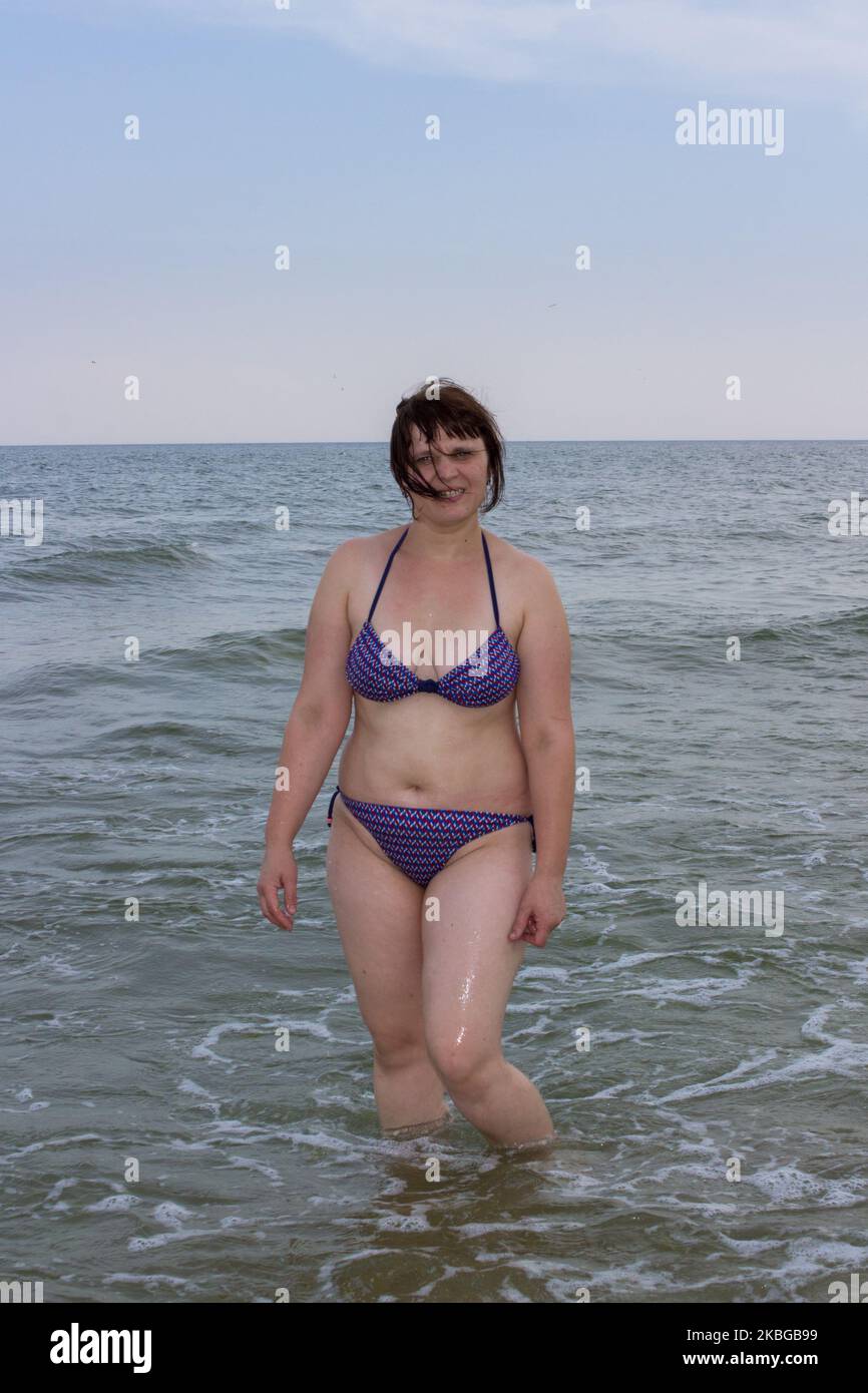 una donna sovrappeso in piedi in acqua in mare Foto Stock una donna sovrappeso in piedi in acqua in mare Foto Stock