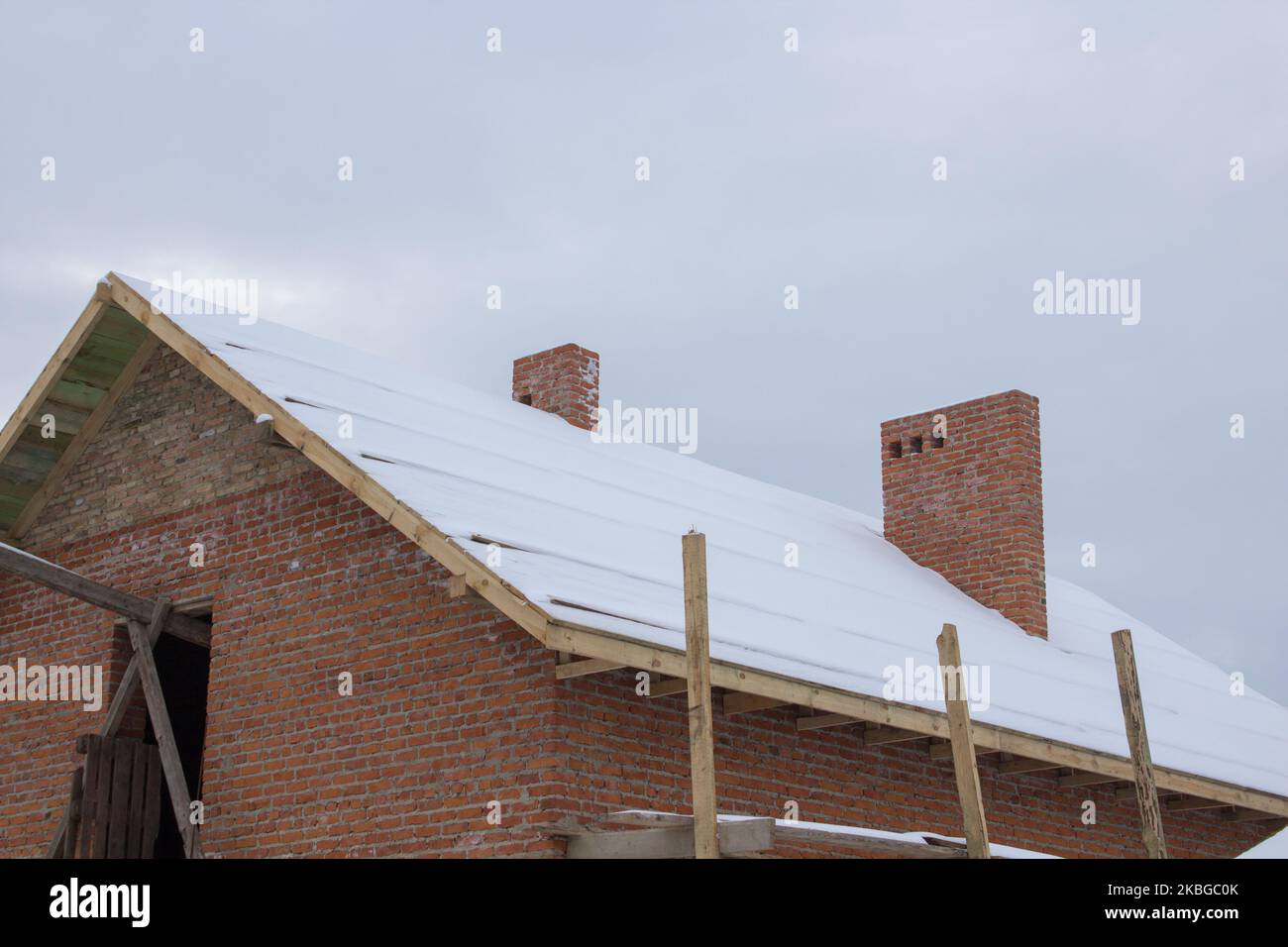 Neve sul tetto di una costruzione incompiuta di una nuova casa Foto Stock