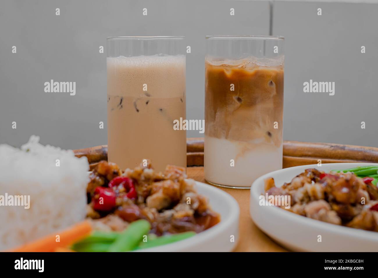 Due bicchieri di latte di caffè in tavolo di legno e sfocato in primo piano Foto Stock