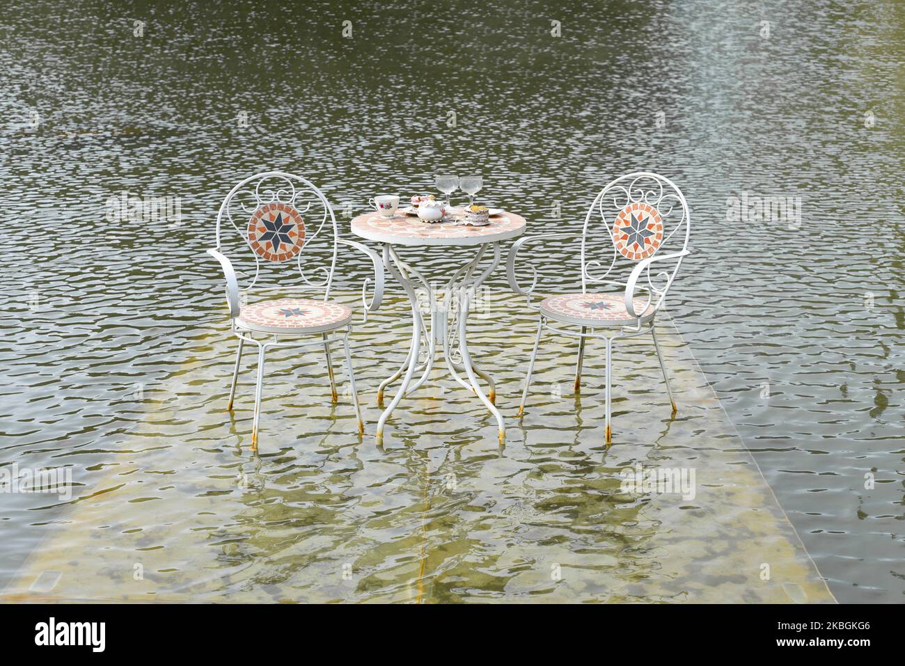 Sedie e tavolino da caffè con tazzine e bicchieri in acqua a da Lat Foto Stock