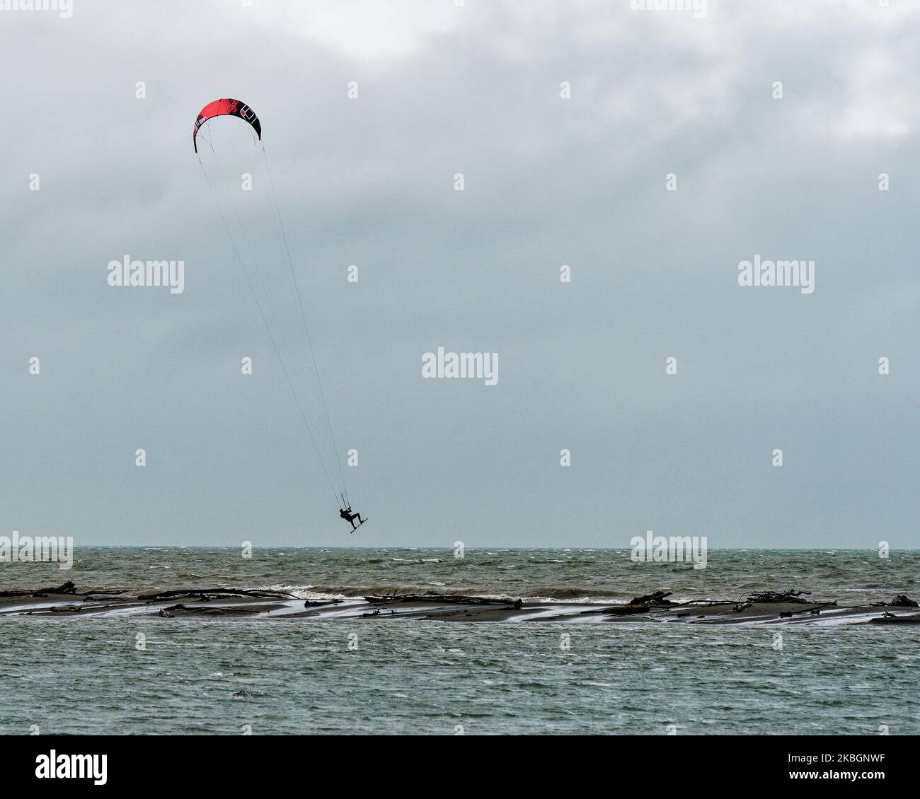 Kite surfer salta il Motueka Sandspit sommerso da una marea alta primavera, Motueka, regione Tasman, isola meridionale, Aotearoa / Nuova Zelanda. Foto Stock