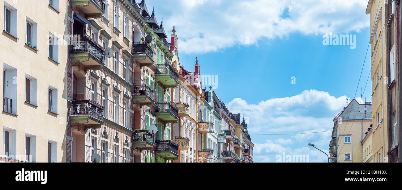 Vista prospettica sugli affittuari a Nysa, Polonia, in una giornata di sole e d'estate. Facciate ornamentali con finestre decorative e balconi contro il blu, nuvoloso sk Foto Stock